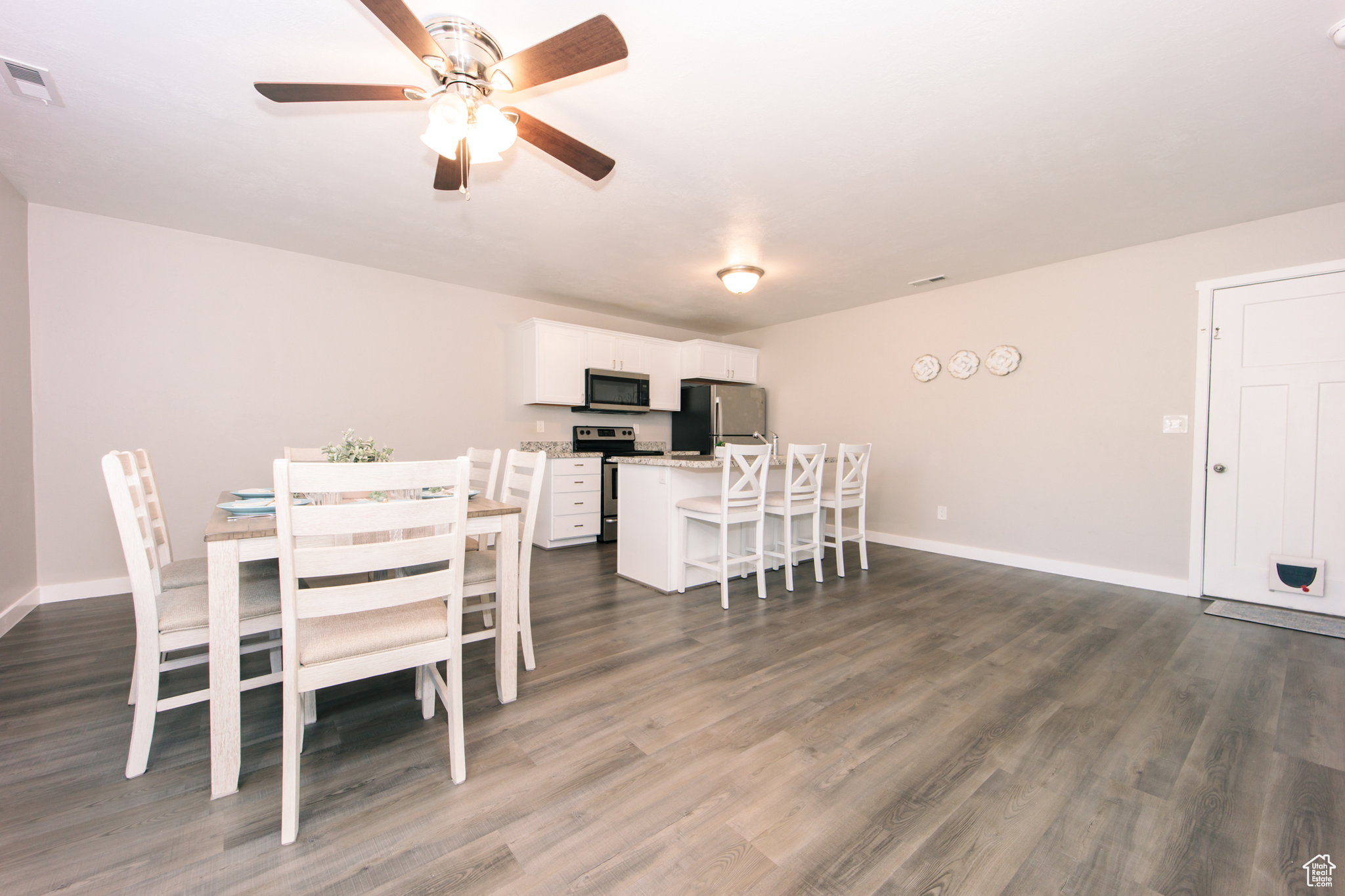 Dining space featuring dark wood-type flooring and ceiling fan