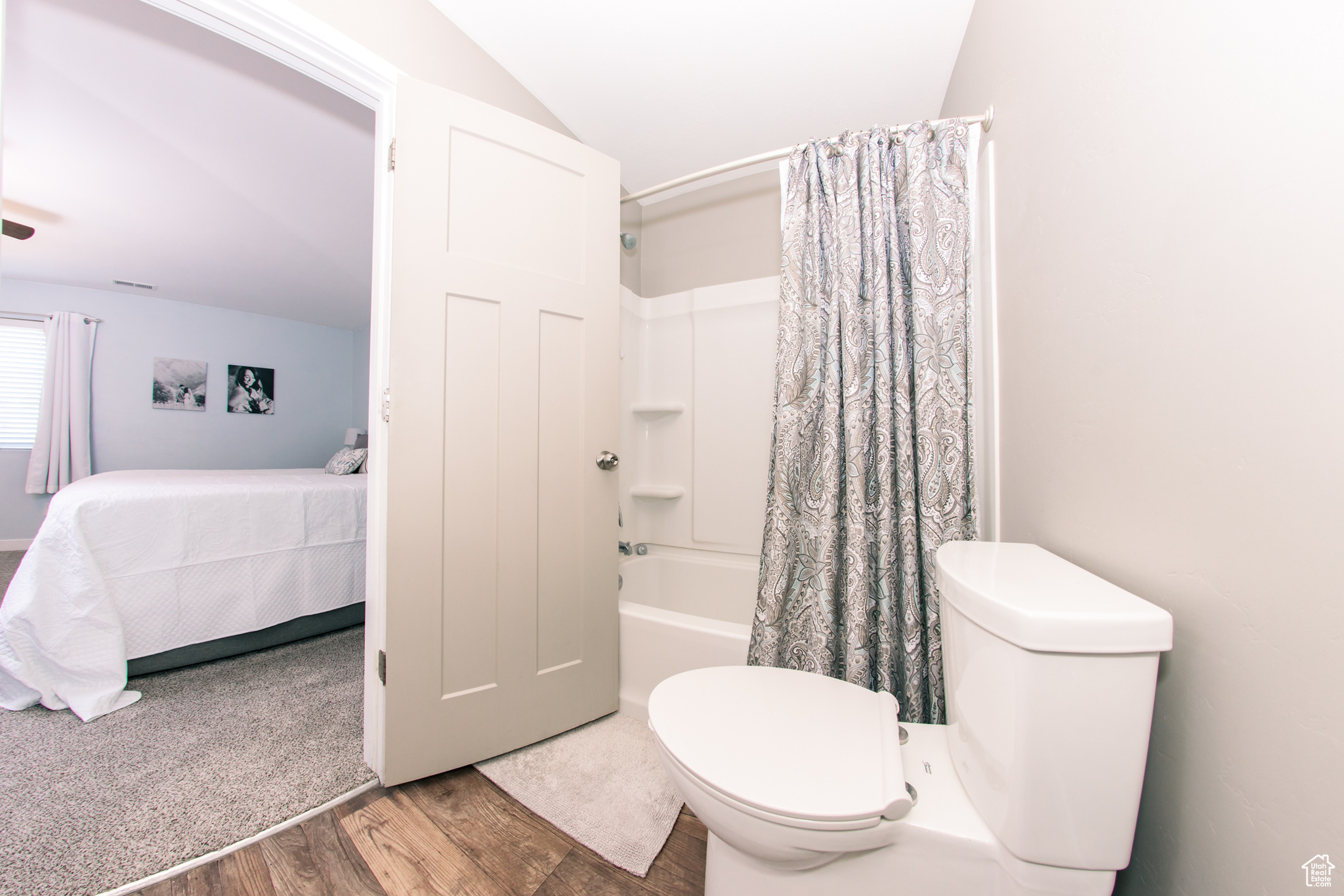 Bathroom with hardwood / wood-style flooring, toilet, and shower / tub combo