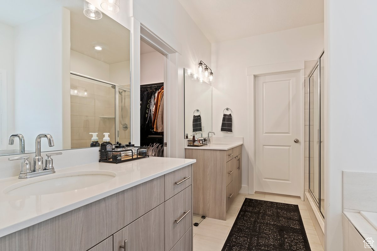Bathroom featuring 2 vanities, a shower with shower door, and tile patterned flooring.  Barn Door Opening.