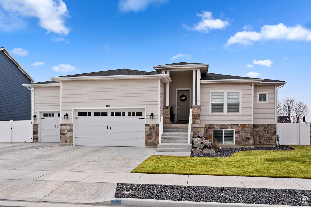 View of front of property featuring a garage and a front lawn