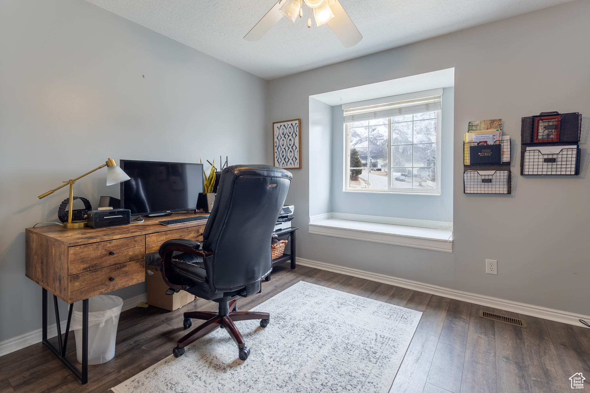 Home office featuring dark hardwood / wood-style flooring and ceiling fan