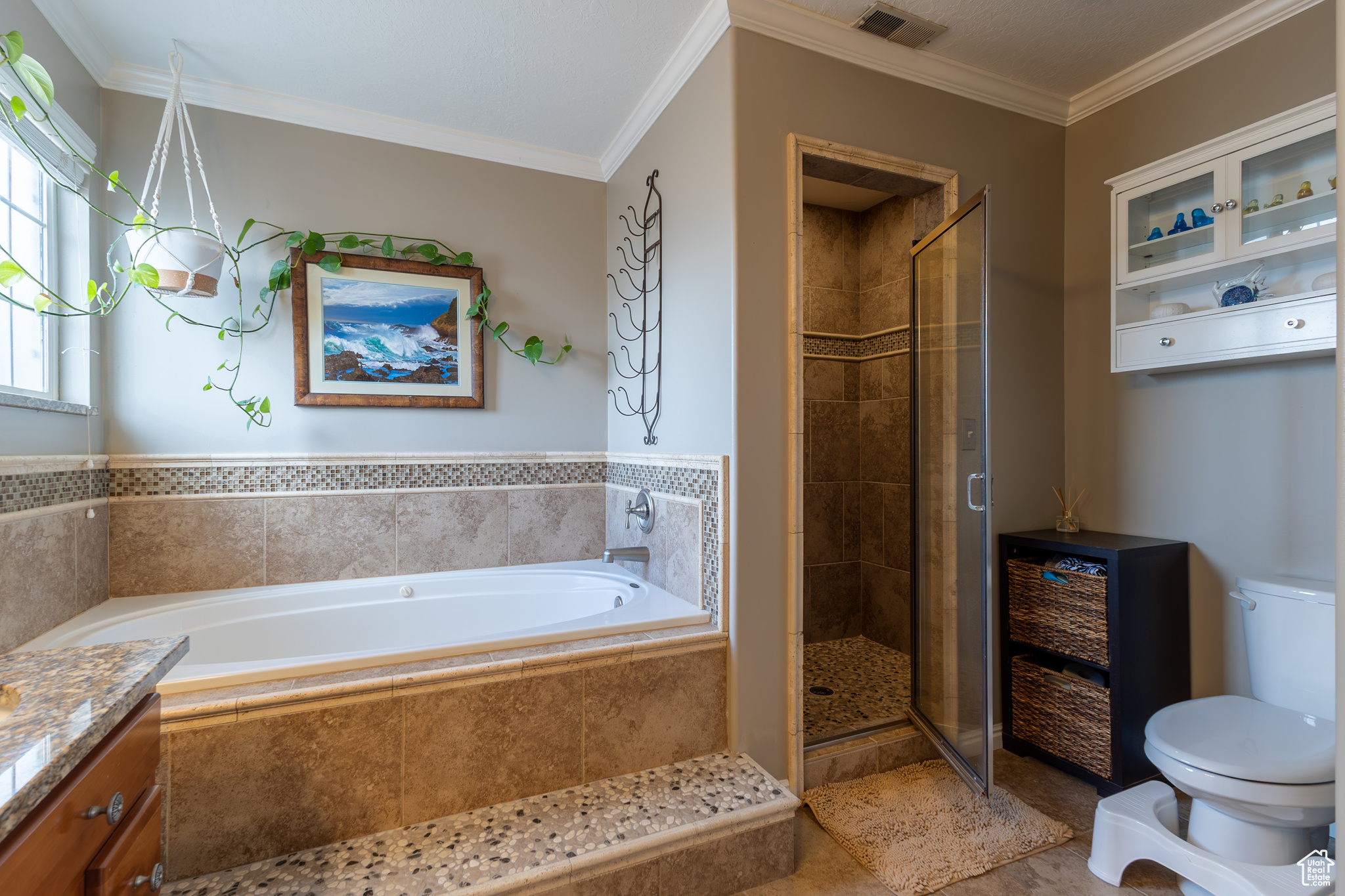 Full bathroom featuring crown molding, tile patterned floors, toilet, and plus walk in shower
