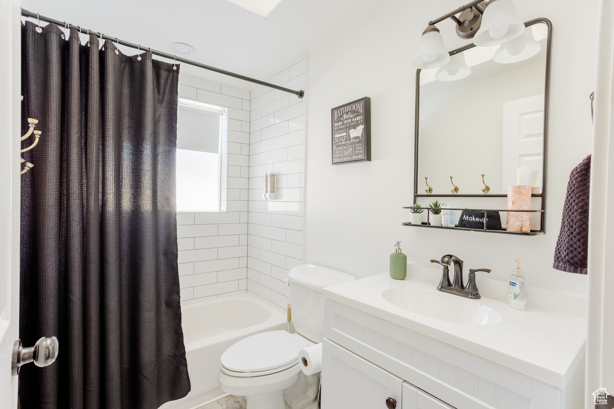 Full bathroom with shower / tub combo, vanity, and toilet