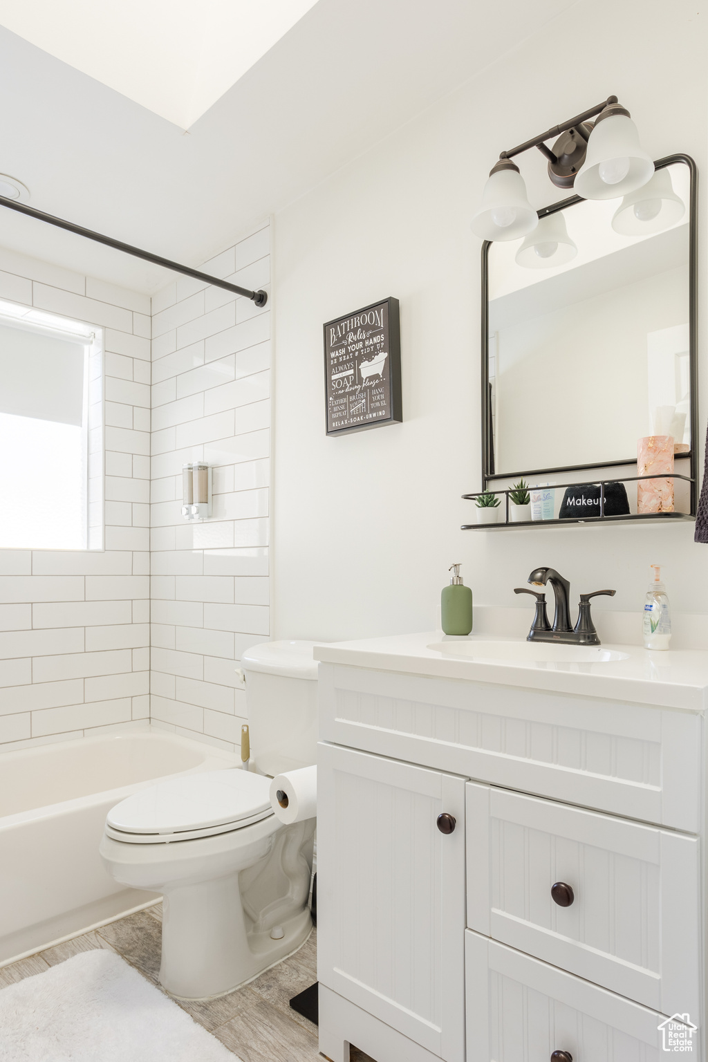 Full bathroom featuring tiled shower / bath, vanity, and toilet