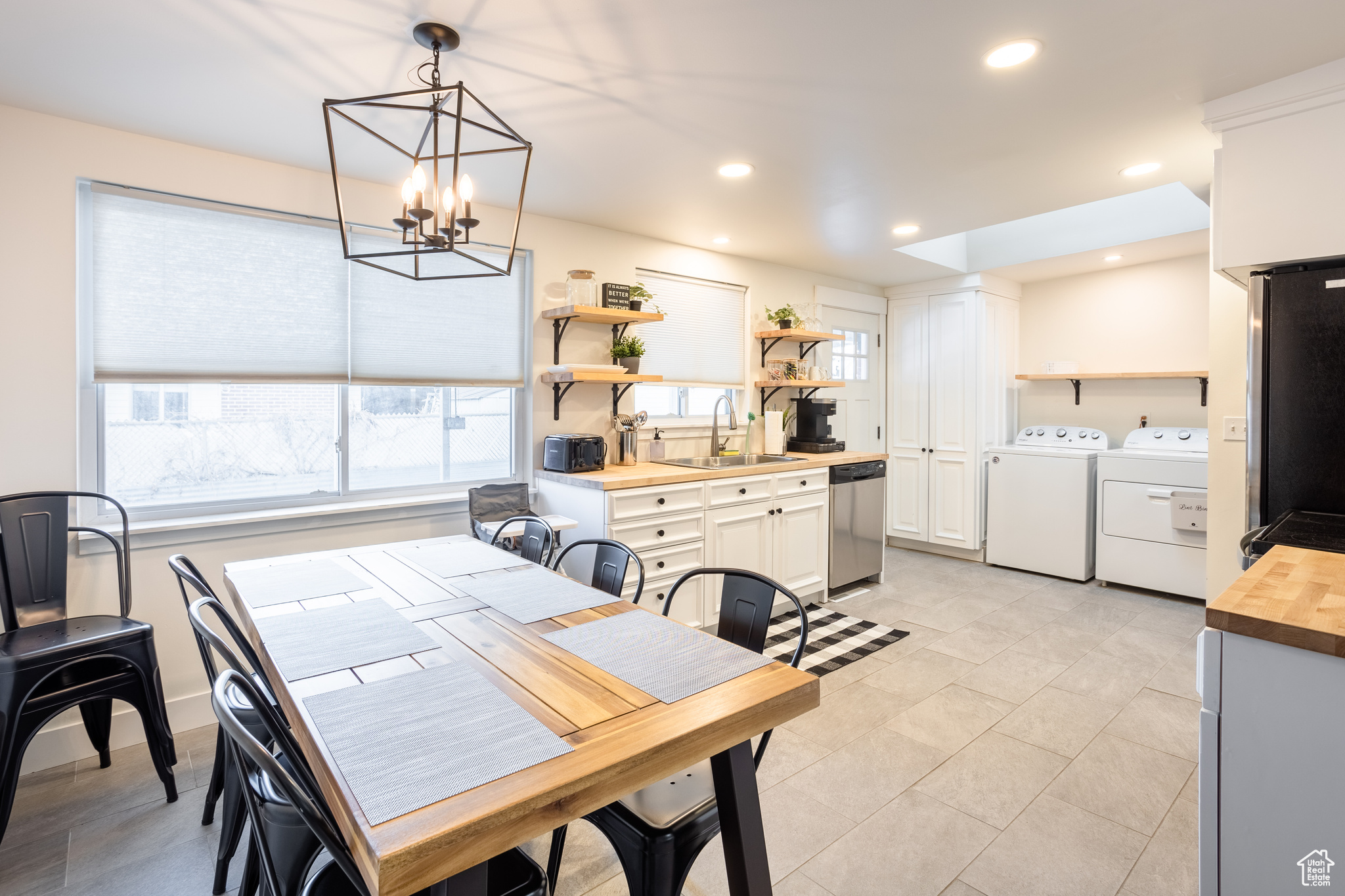 Dining room with sink, a notable chandelier, and washer and clothes dryer