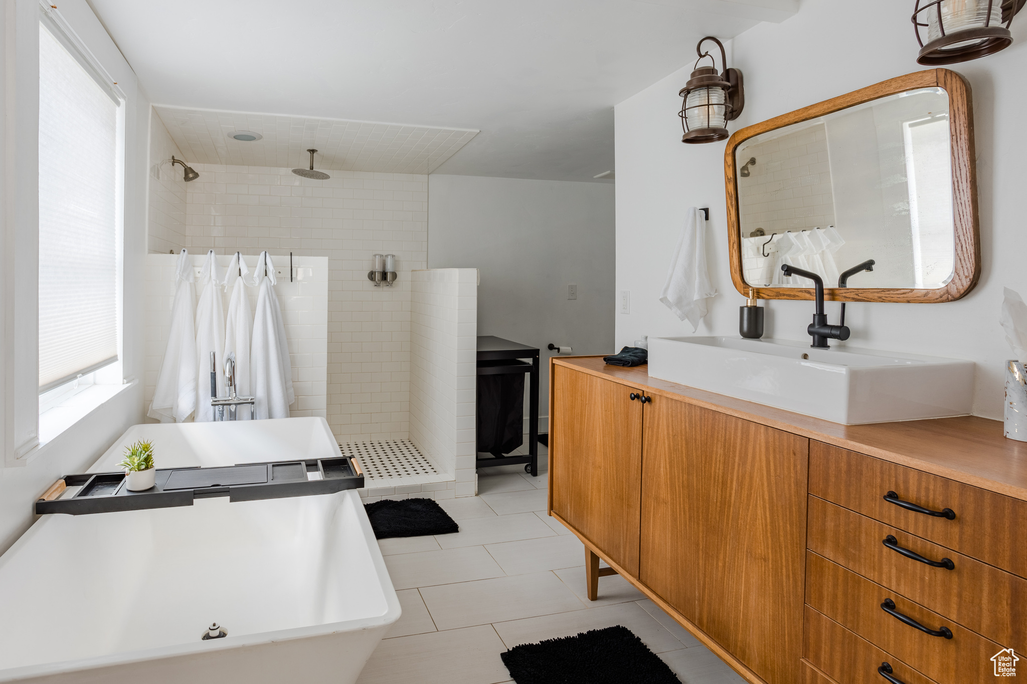 Bathroom with vanity, tile patterned flooring, and tiled shower