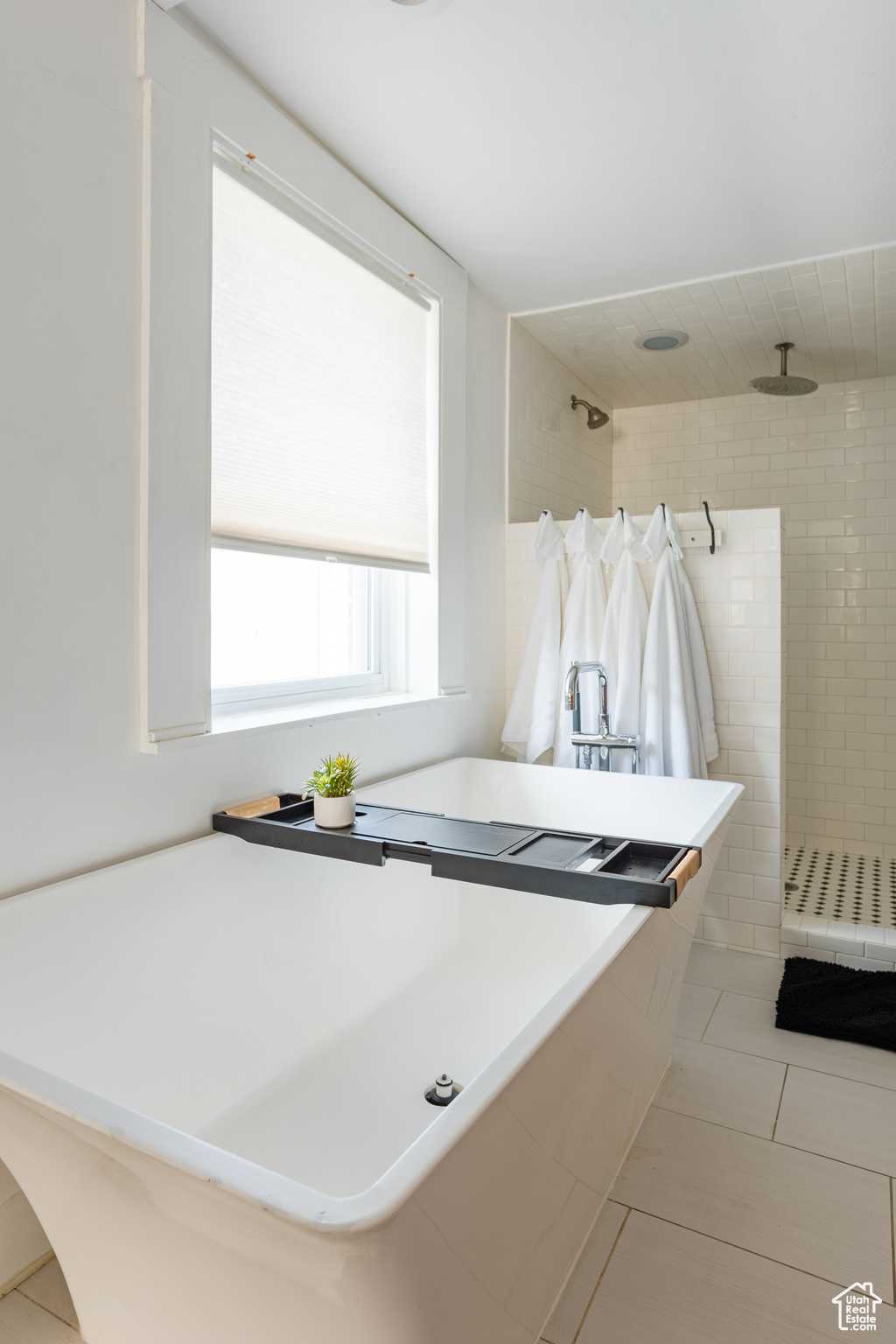 Bathroom with tile patterned flooring and a tile shower