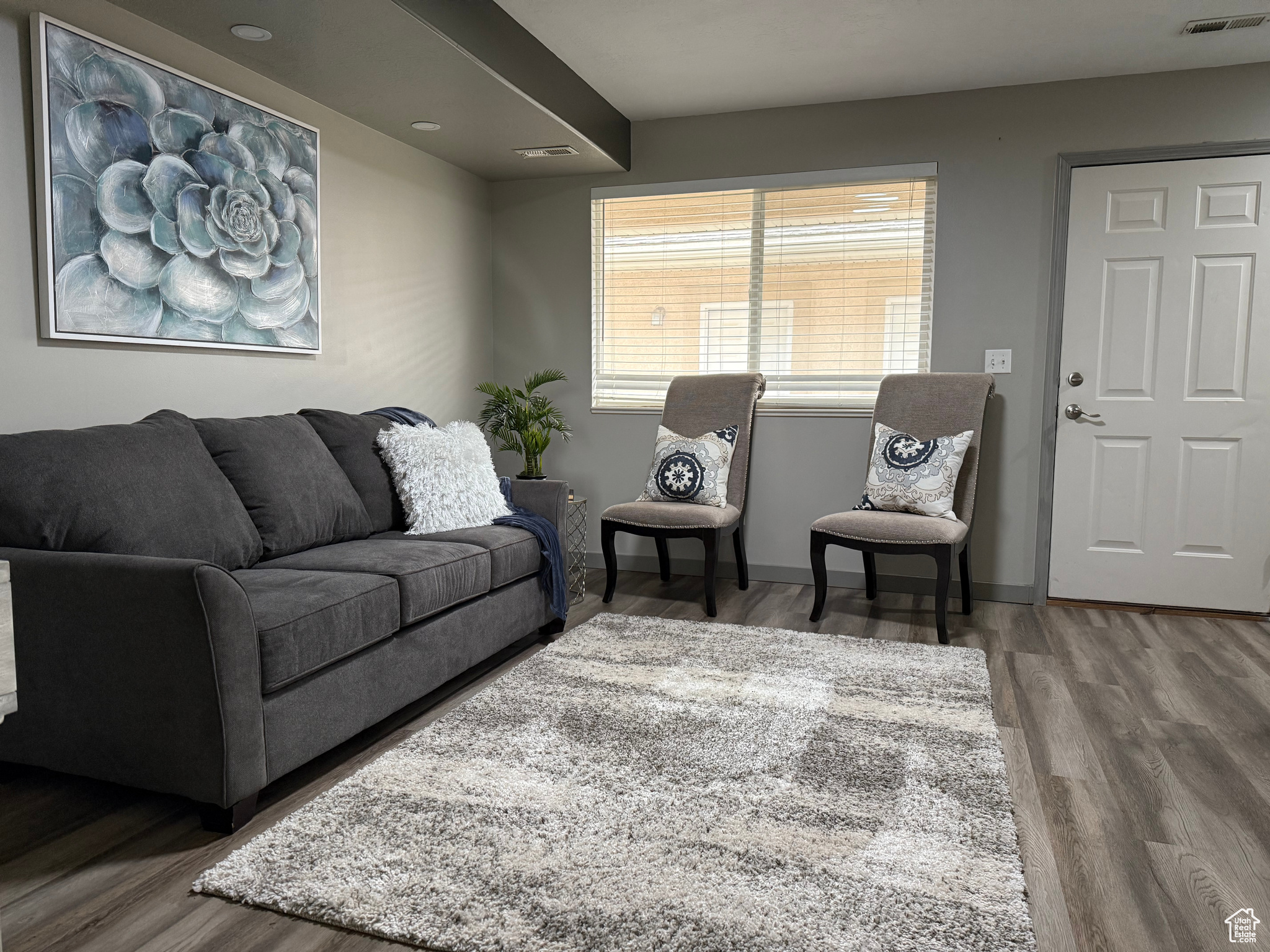 Living area with visible vents, baseboards, and wood finished floors