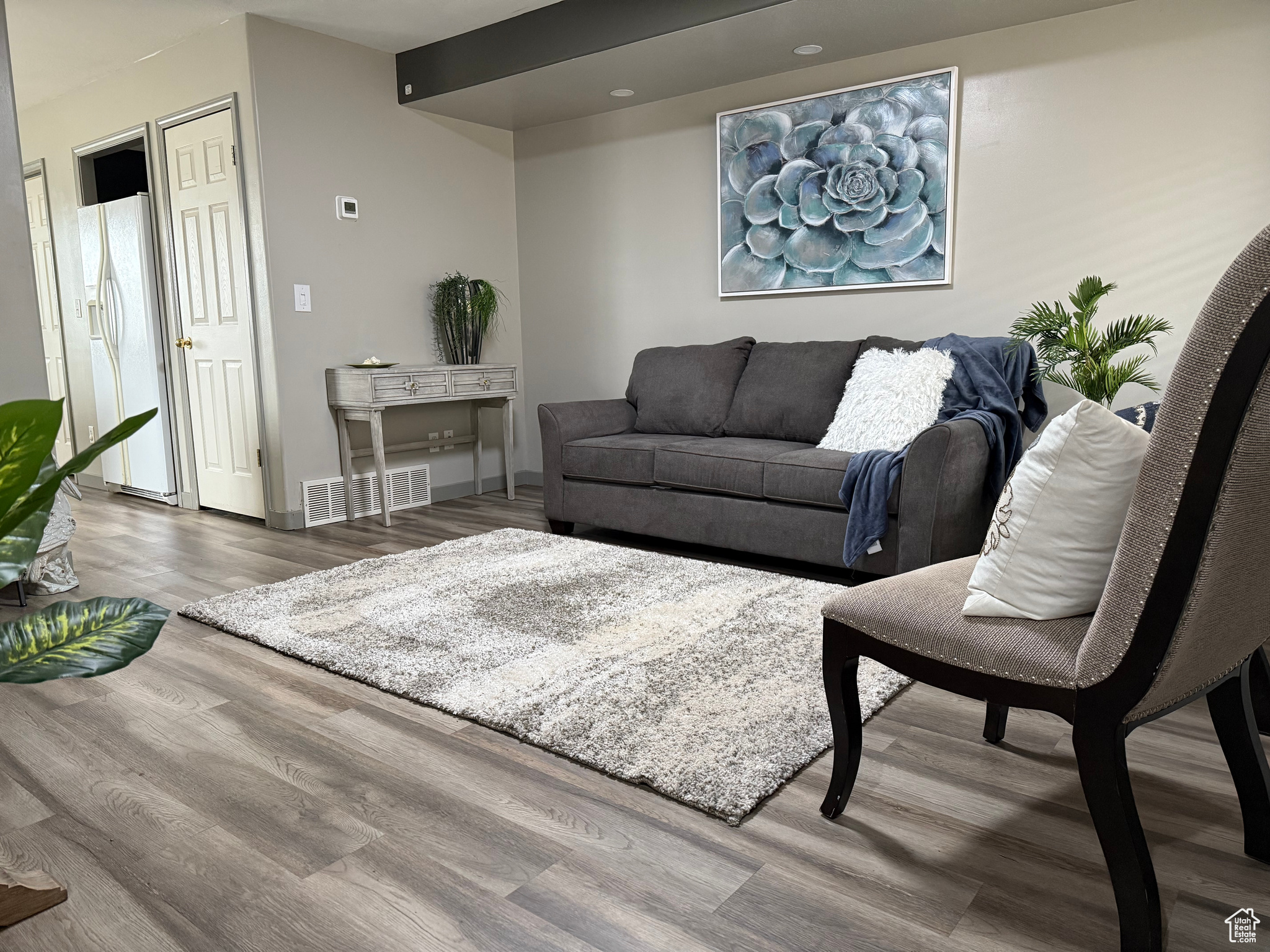 Living area featuring visible vents, baseboards, and wood finished floors