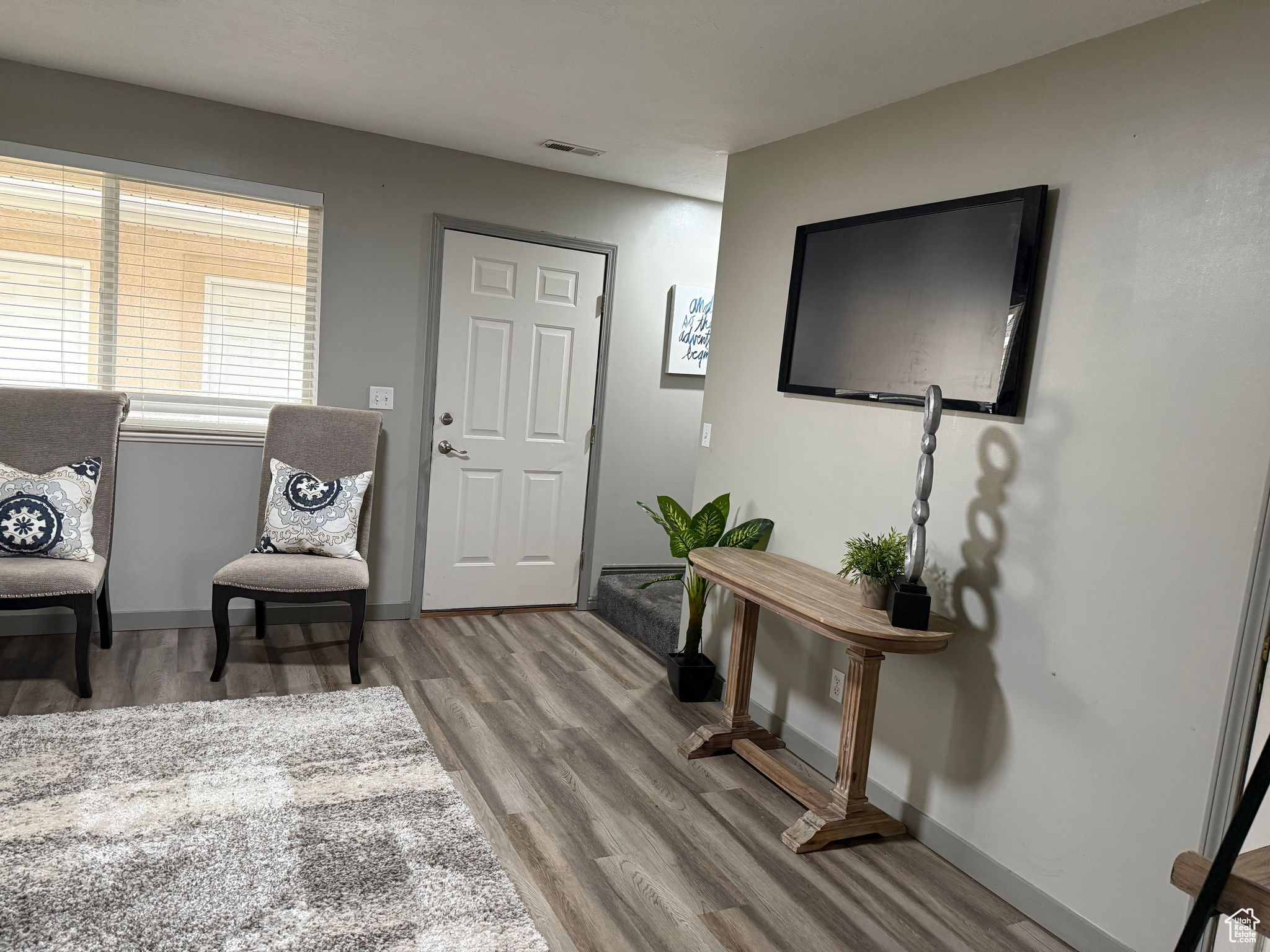 Living area with visible vents, light wood-type flooring, and baseboards