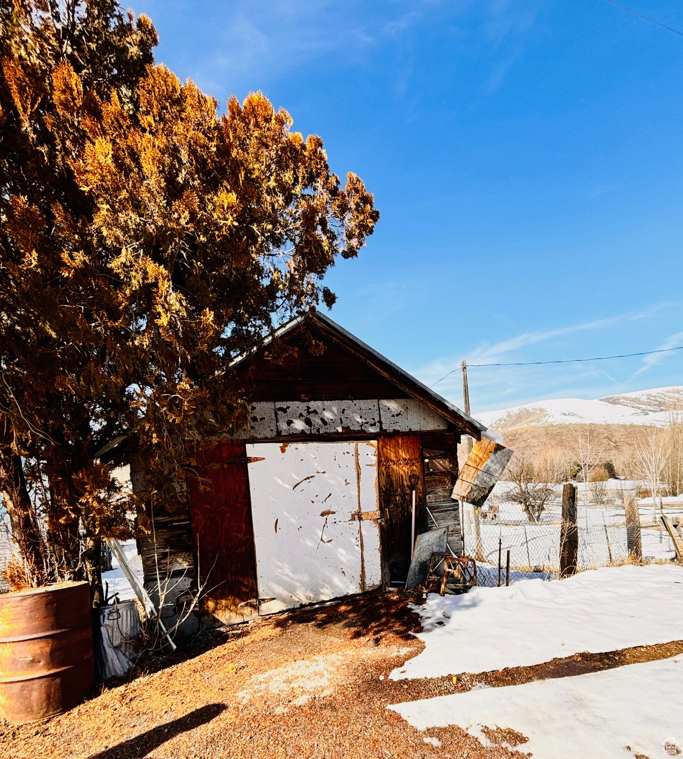 View of outbuilding with a mountain view, an outdoor structure, and fence
