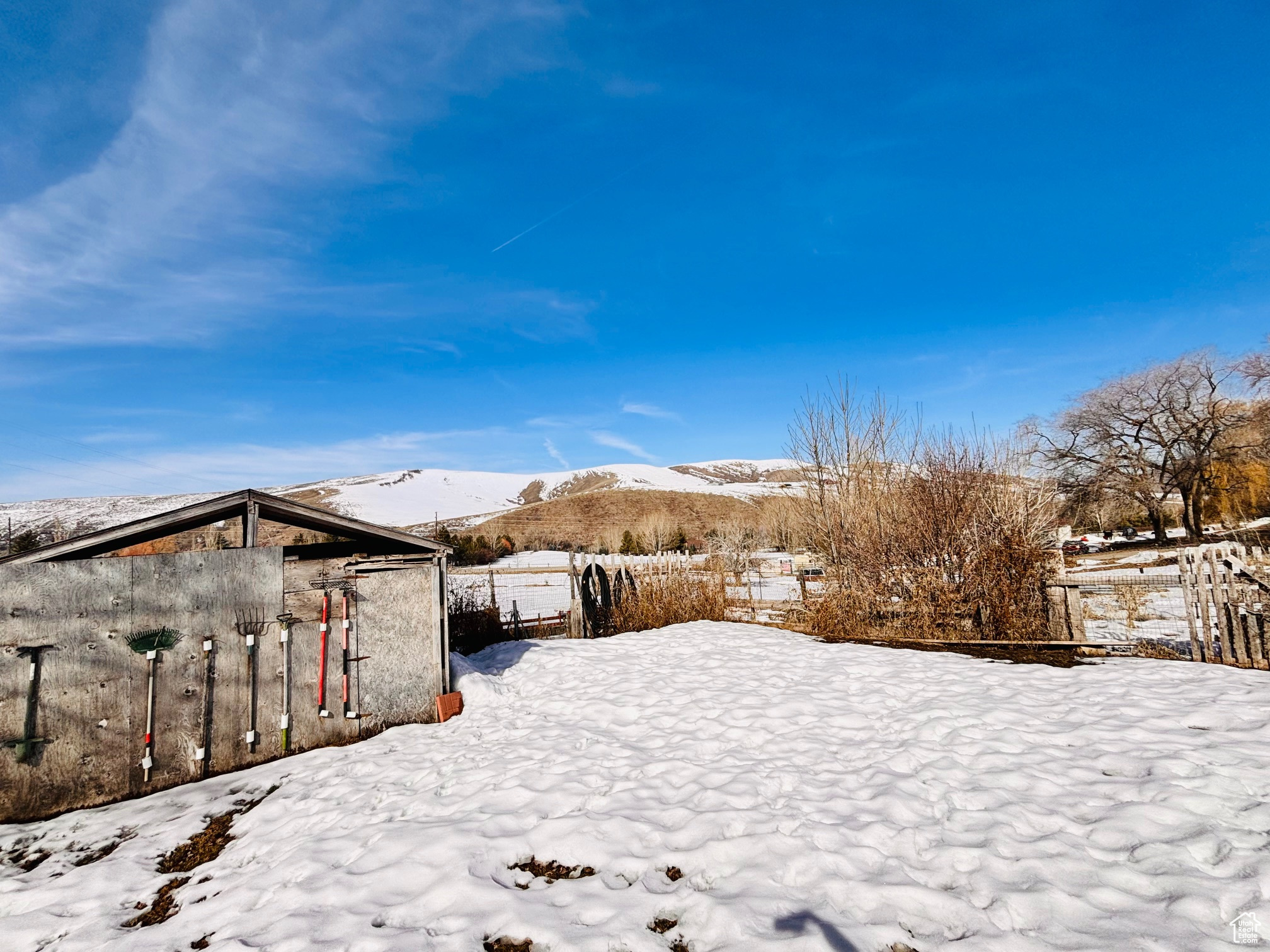 Snowy yard with fence and a mountain view