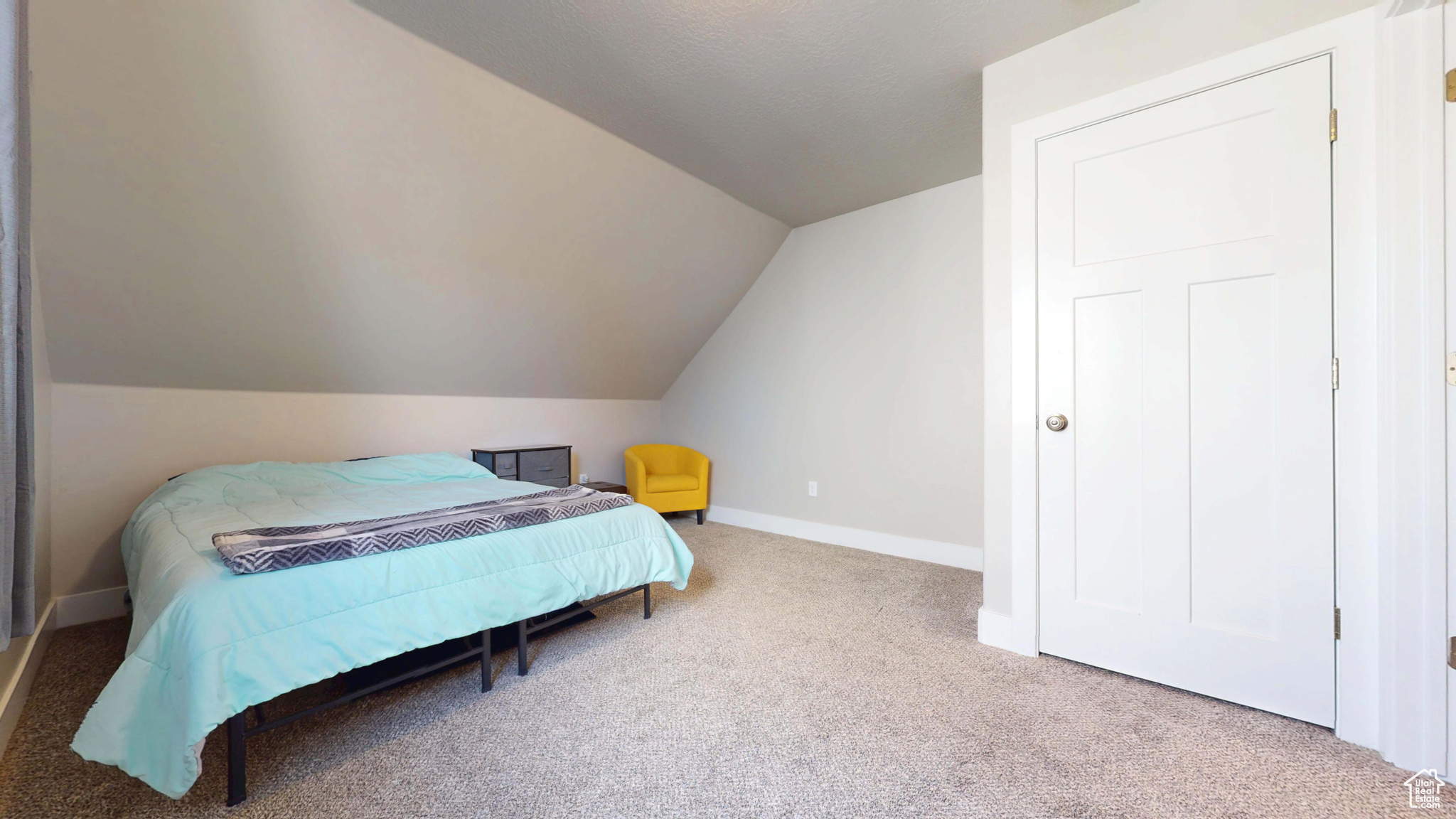 Carpeted bedroom featuring vaulted ceiling