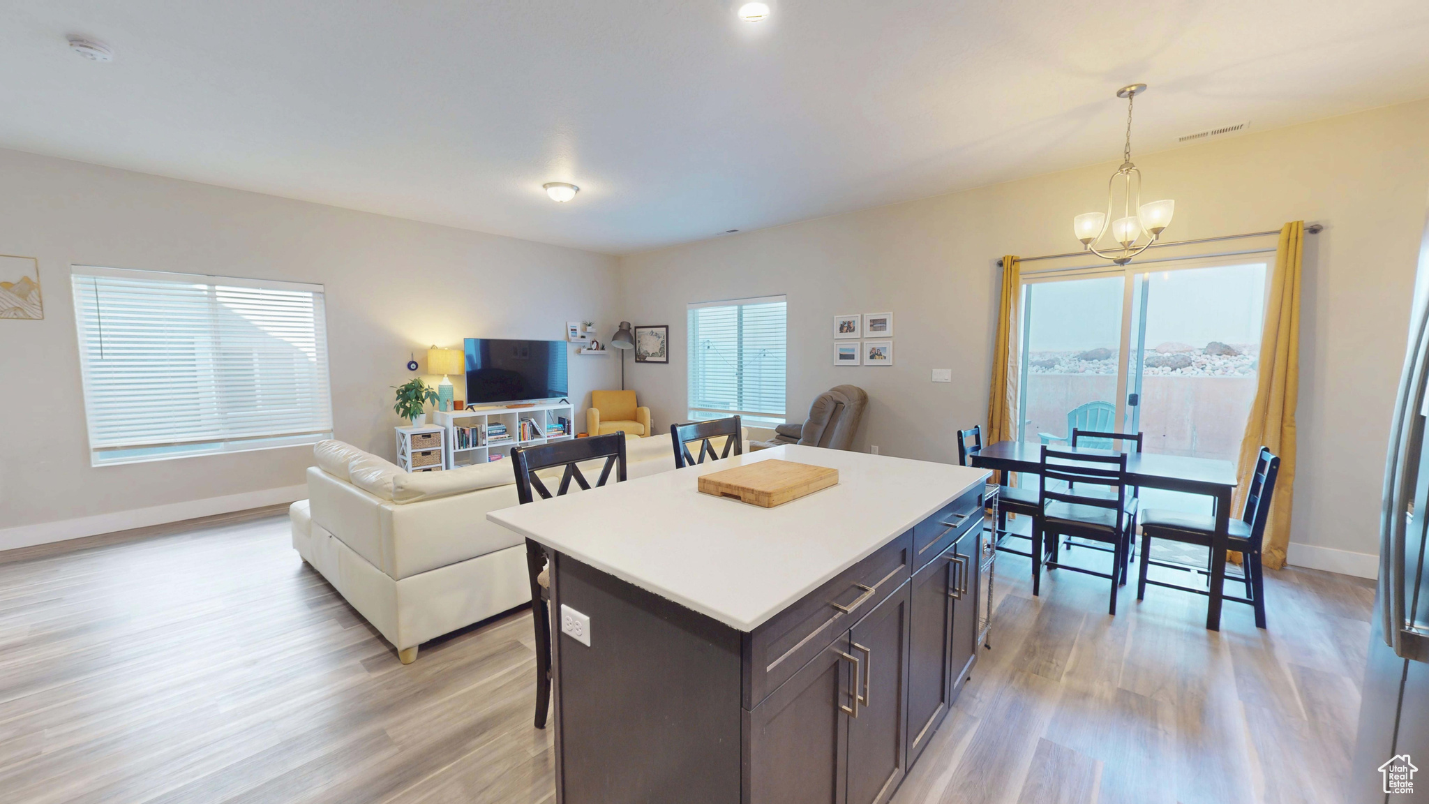 Kitchen with a wealth of natural light, light wood-type flooring, and decorative light fixtures