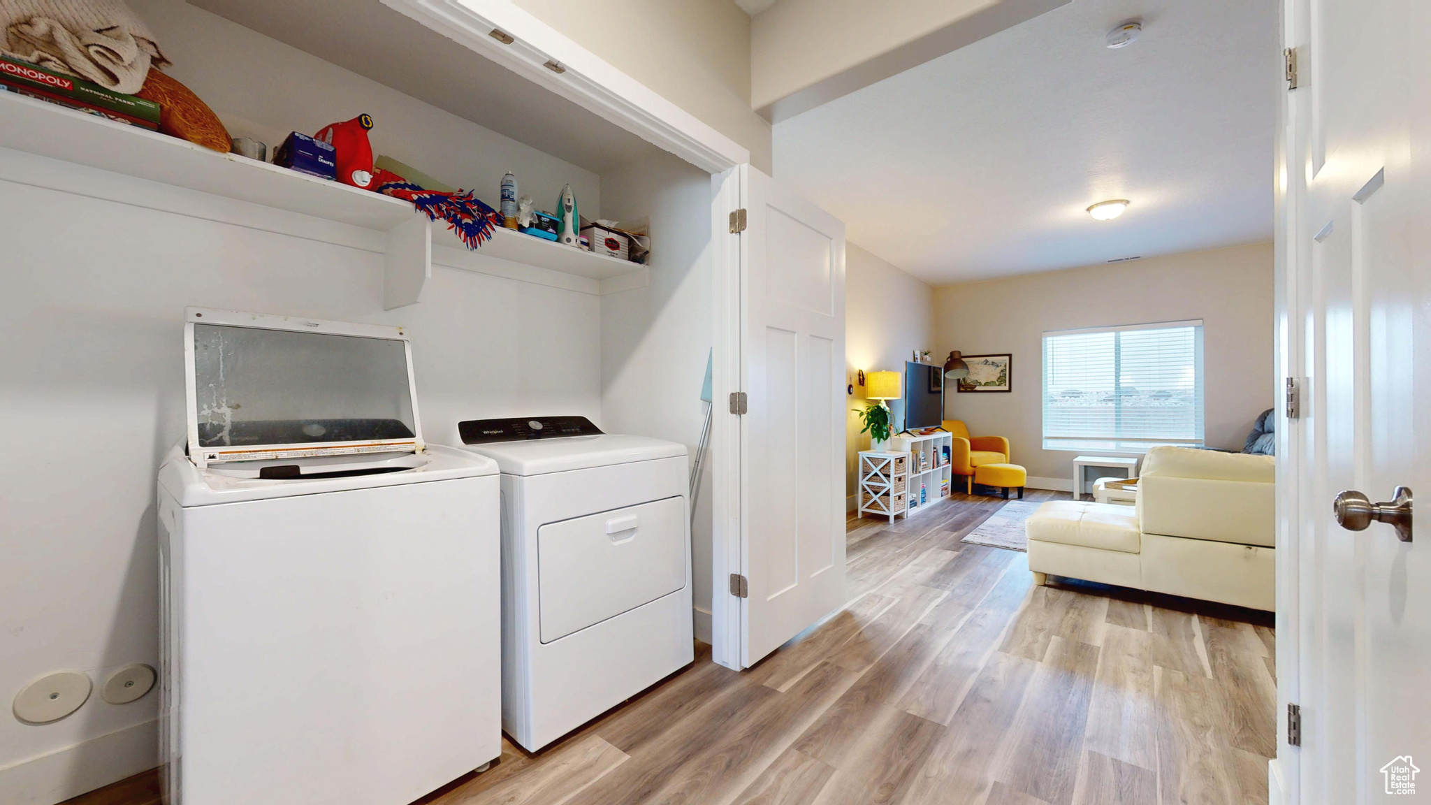 Clothes washing area featuring separate washer and dryer and light hardwood / wood-style floors