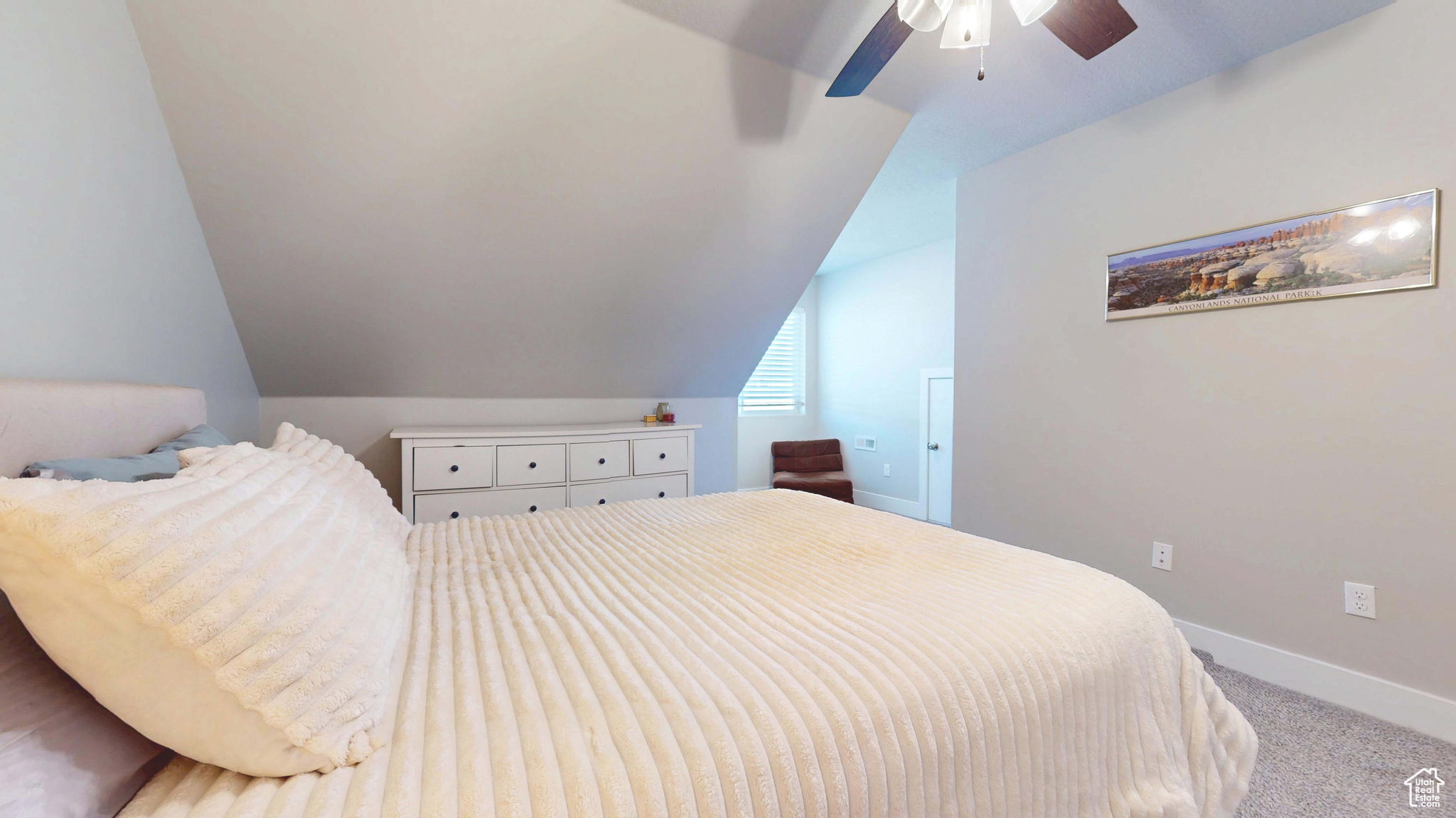 Carpeted bedroom featuring lofted ceiling and ceiling fan