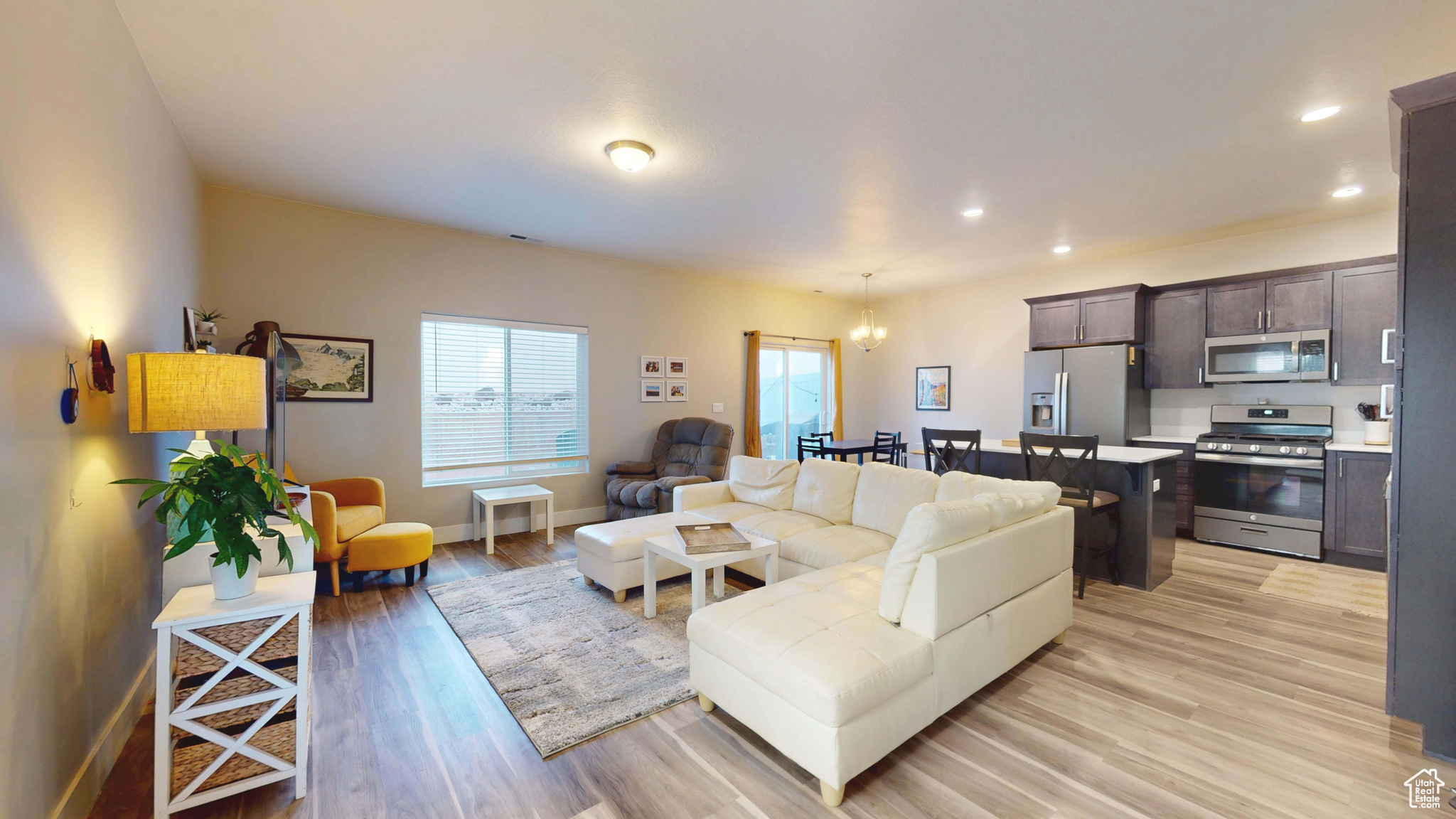 Living room with an inviting chandelier and light hardwood / wood-style flooring