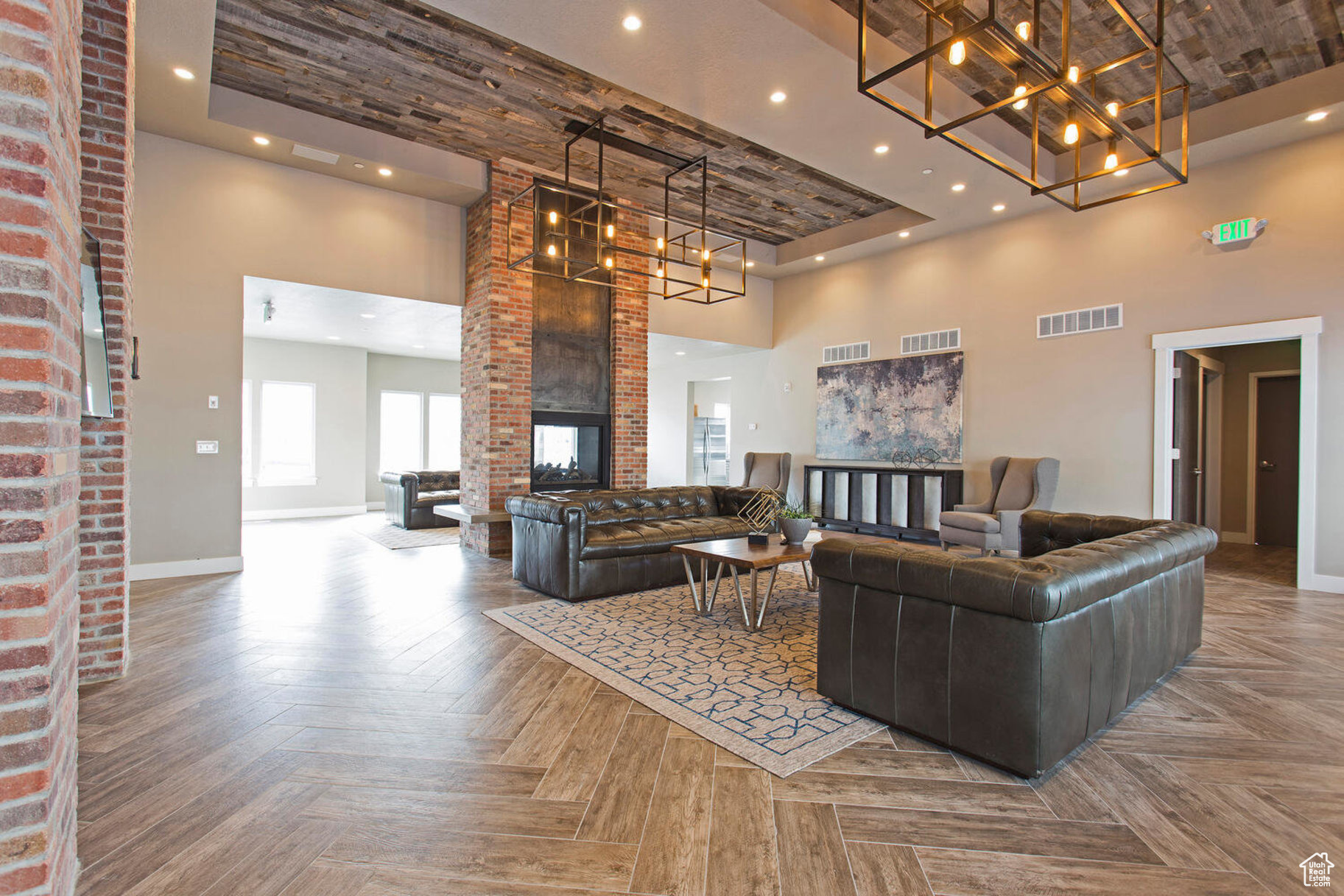 Living room with parquet floors, a towering ceiling, and a brick fireplace