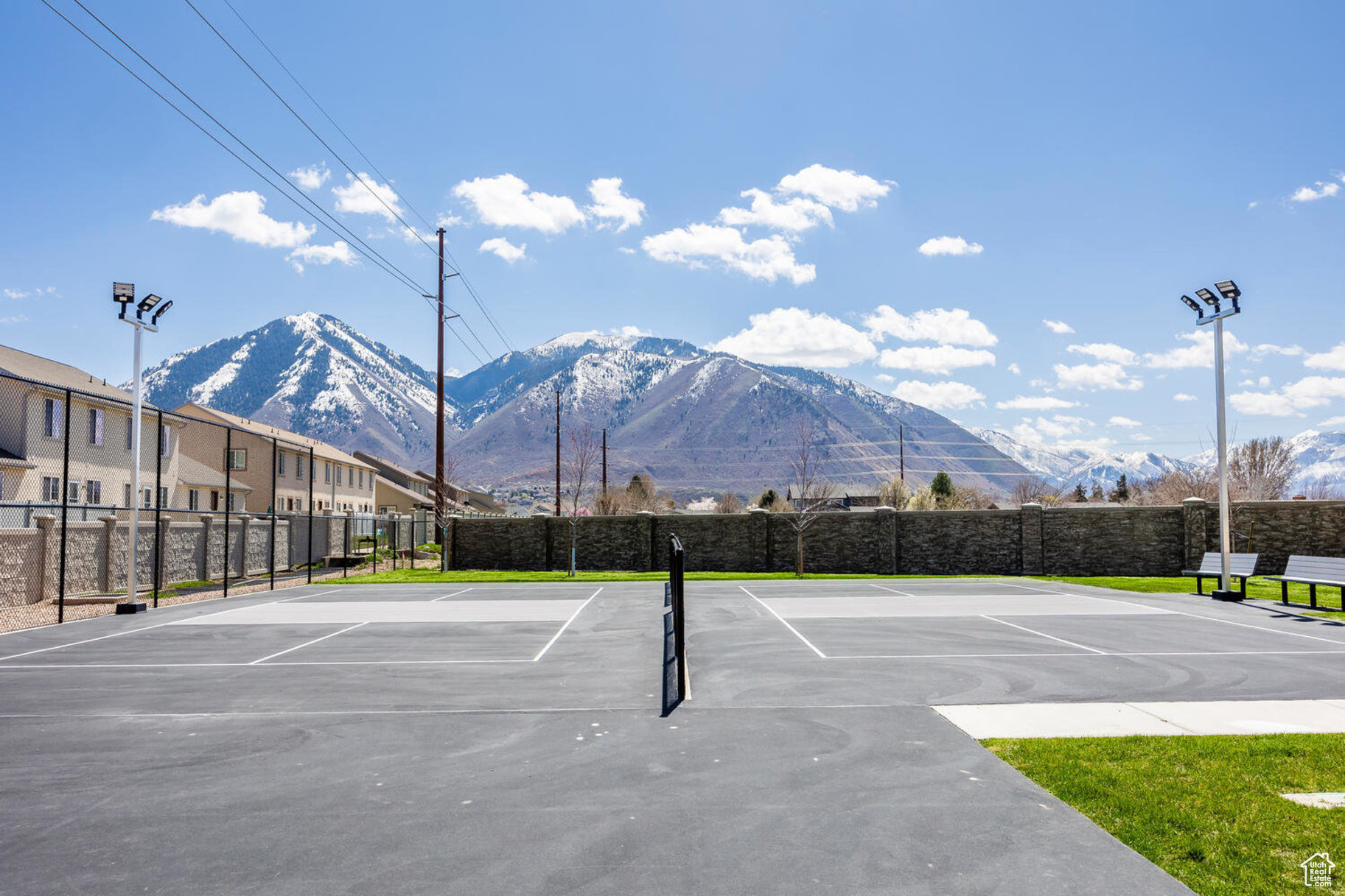 View of tennis court featuring basketball hoop and a mountain view