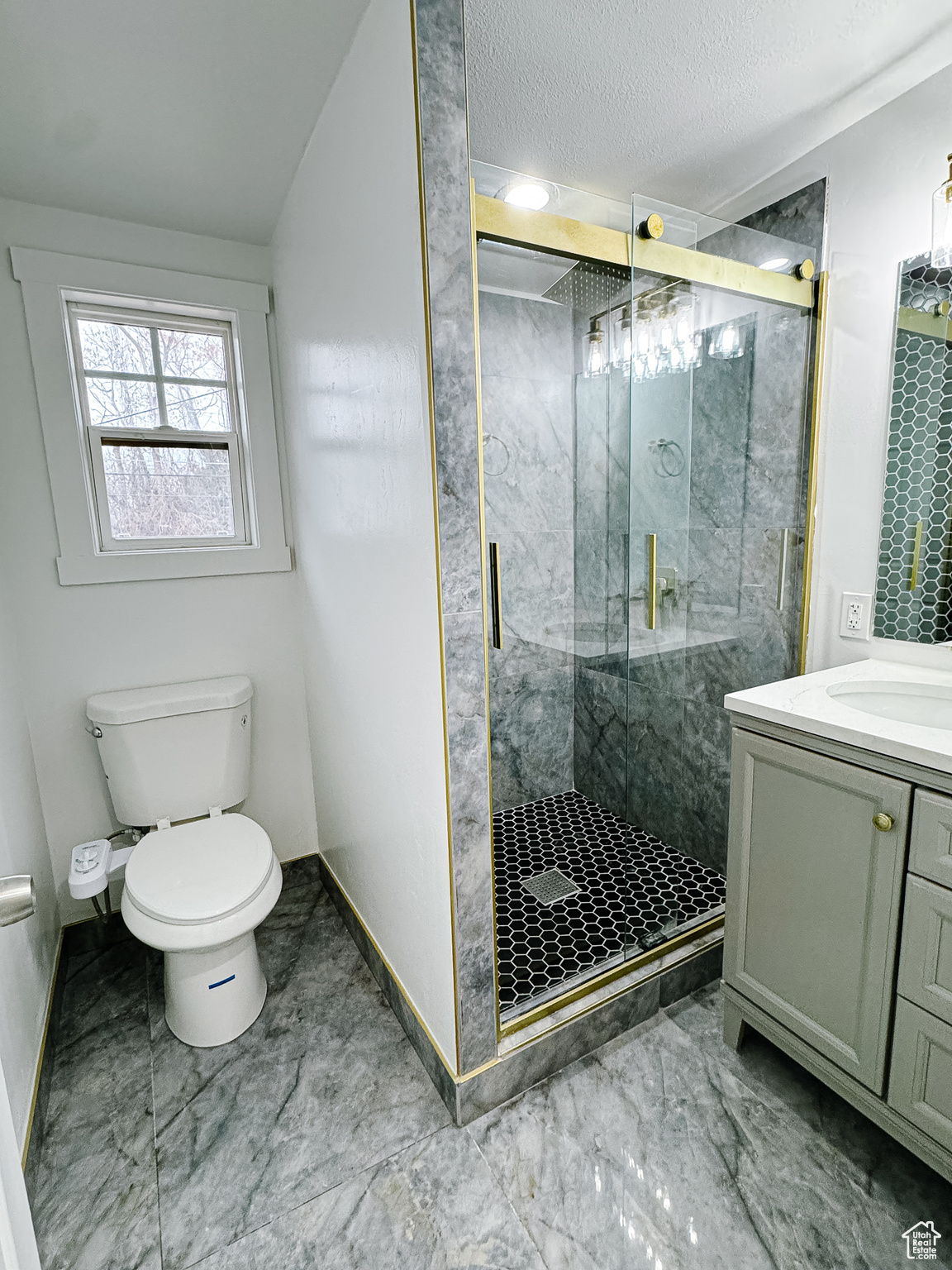 Bathroom with vanity, toilet, a shower with door, and a textured ceiling