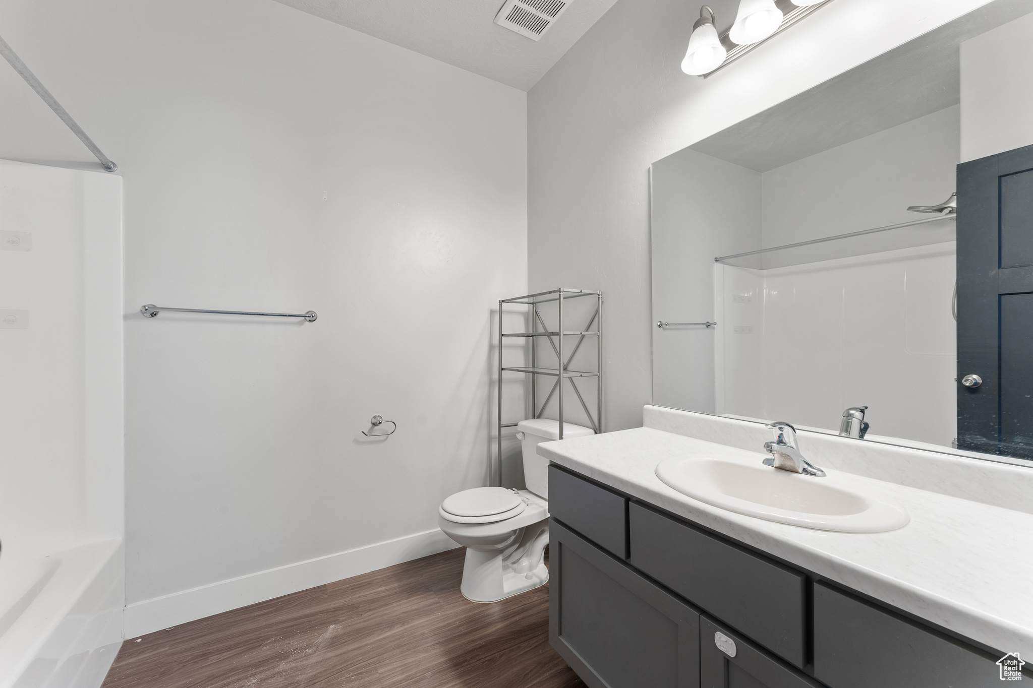 Full bathroom featuring wood-type flooring, toilet, shower / bathing tub combination, and vanity