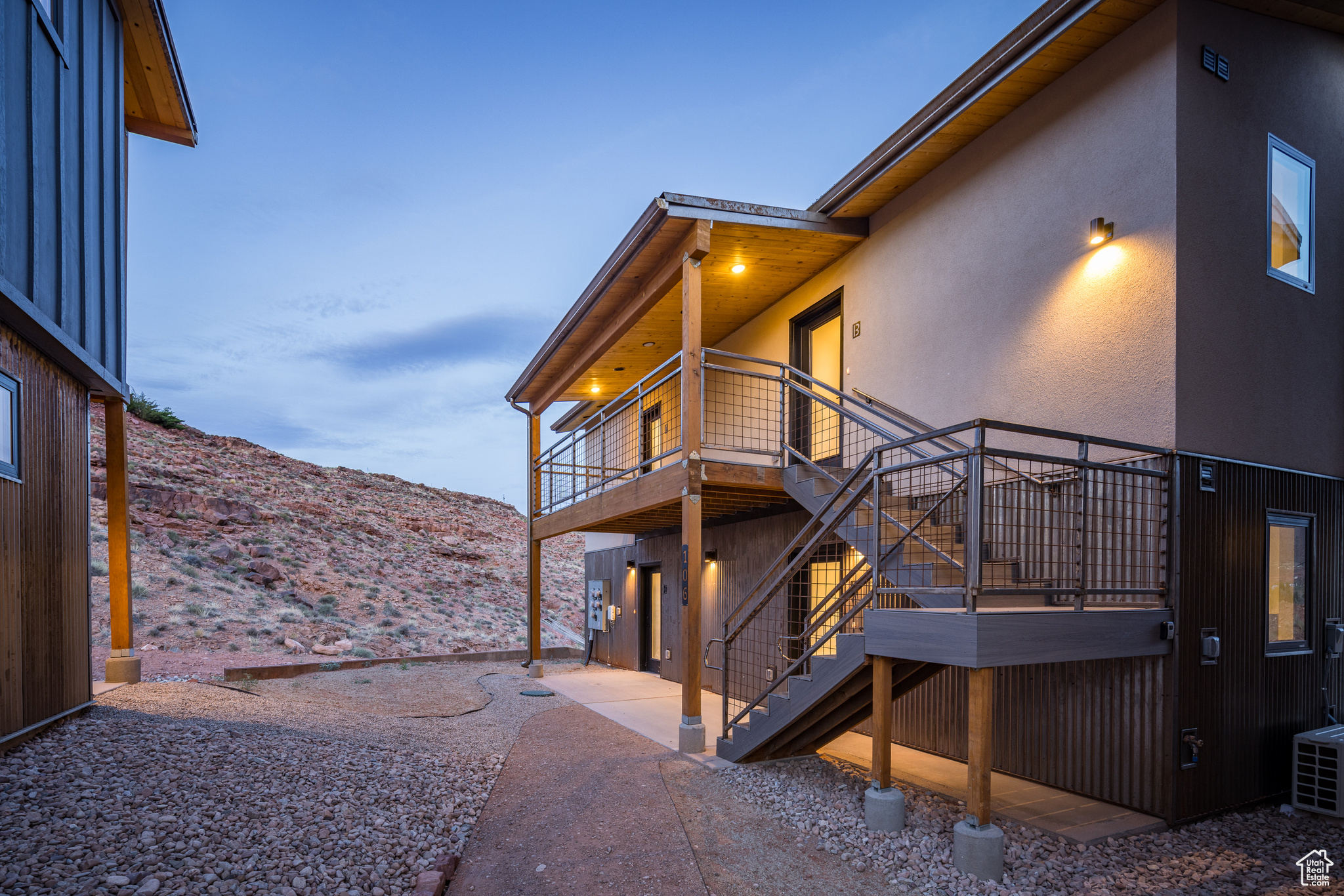 Property exterior at dusk featuring a deck with mountain view and a patio