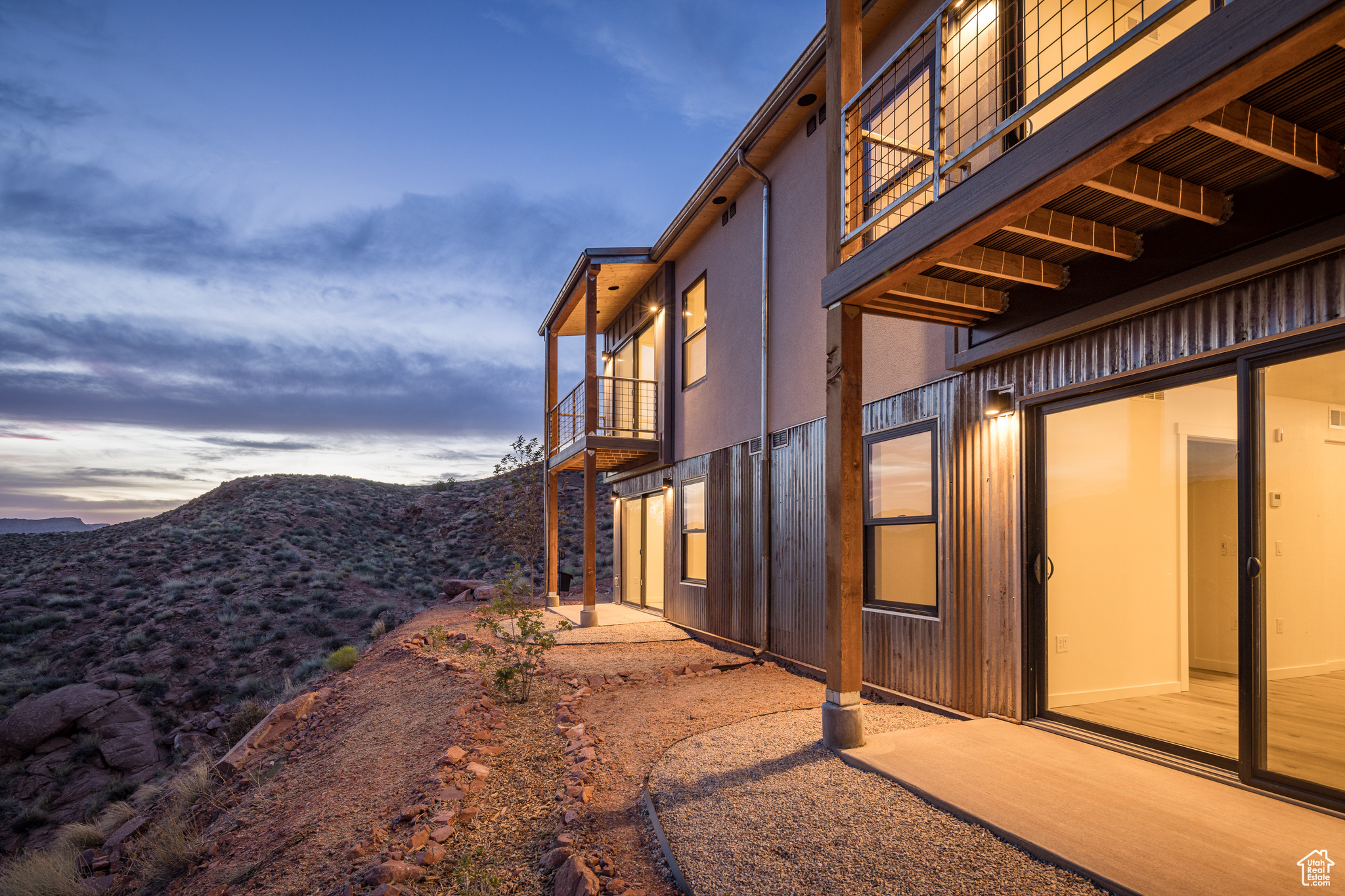 Property exterior at dusk featuring a mountain view and a balcony
