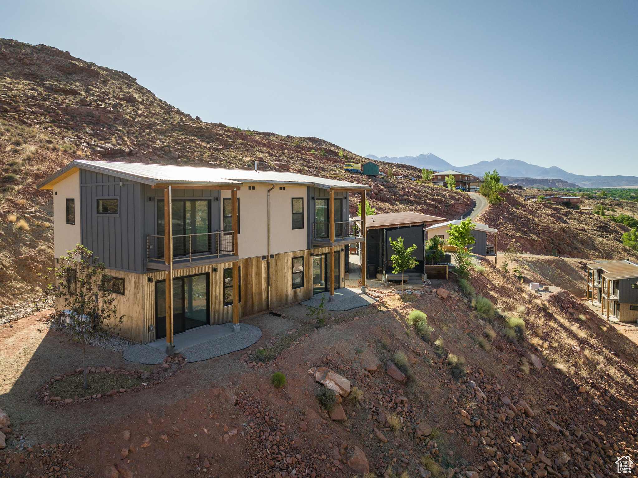 Rear view of house with a mountain view, a sunroom, and a patio