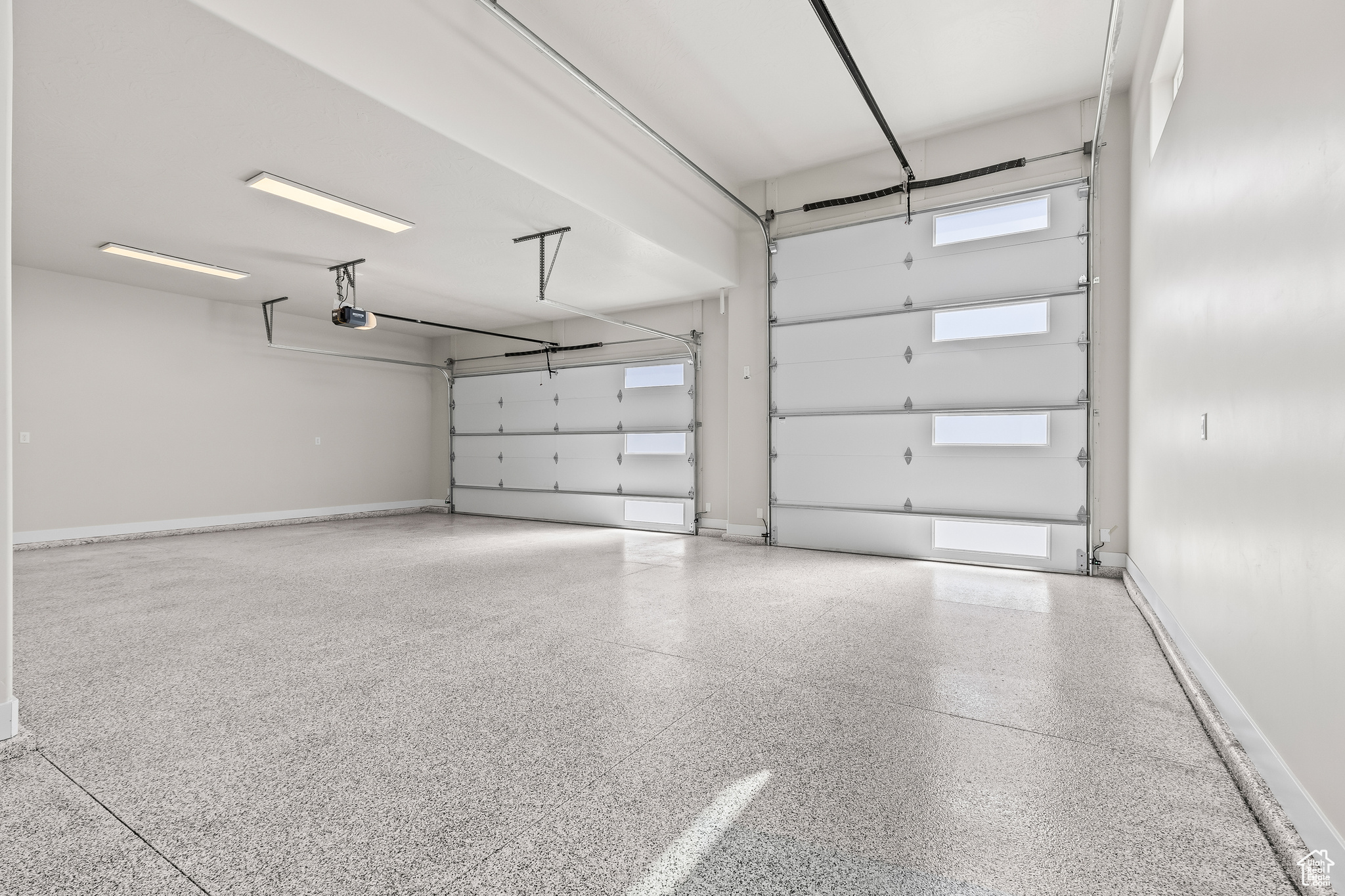 Garage with a garage door opener and baseboards
