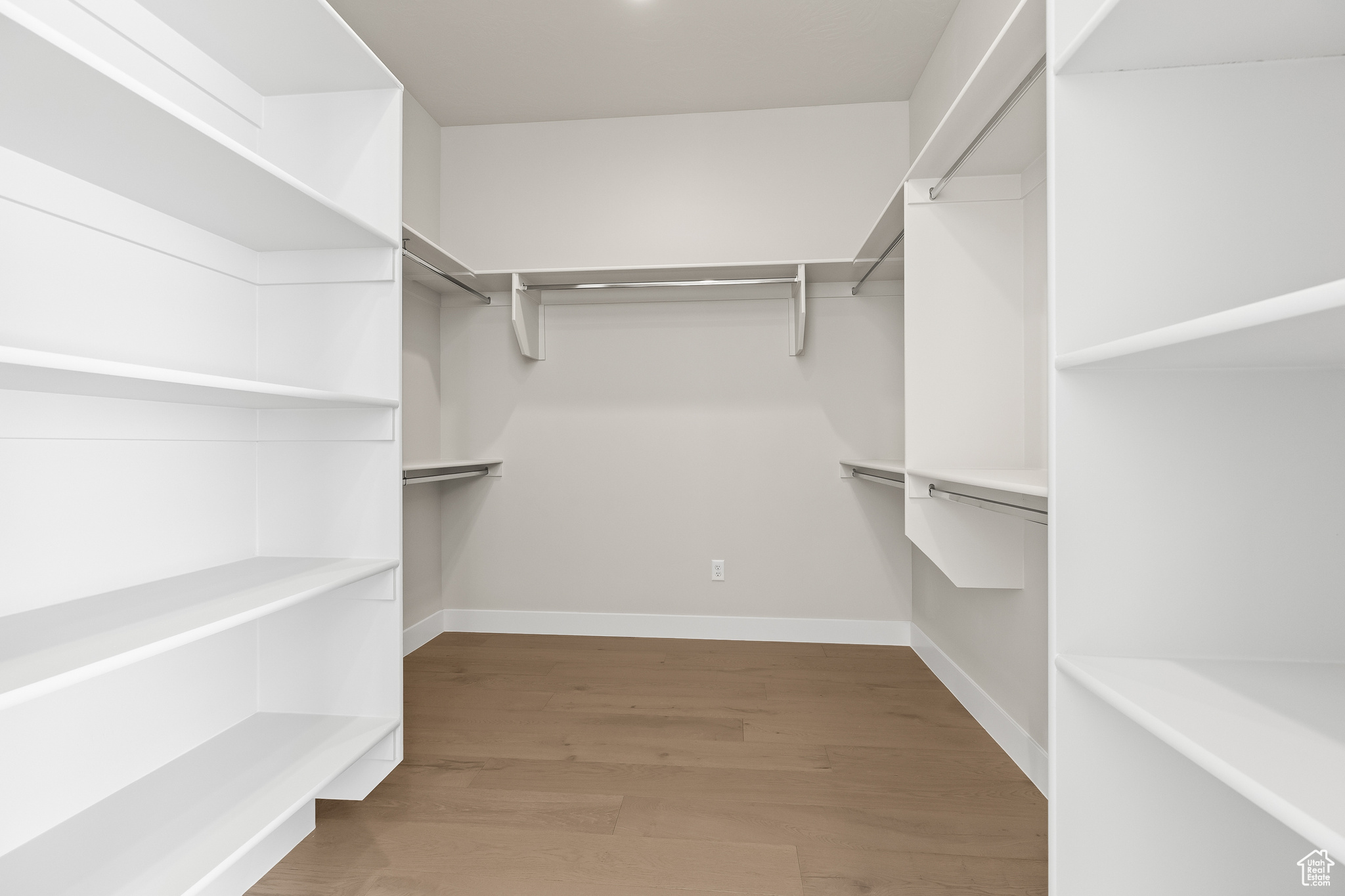 Walk in closet with wood finished floors