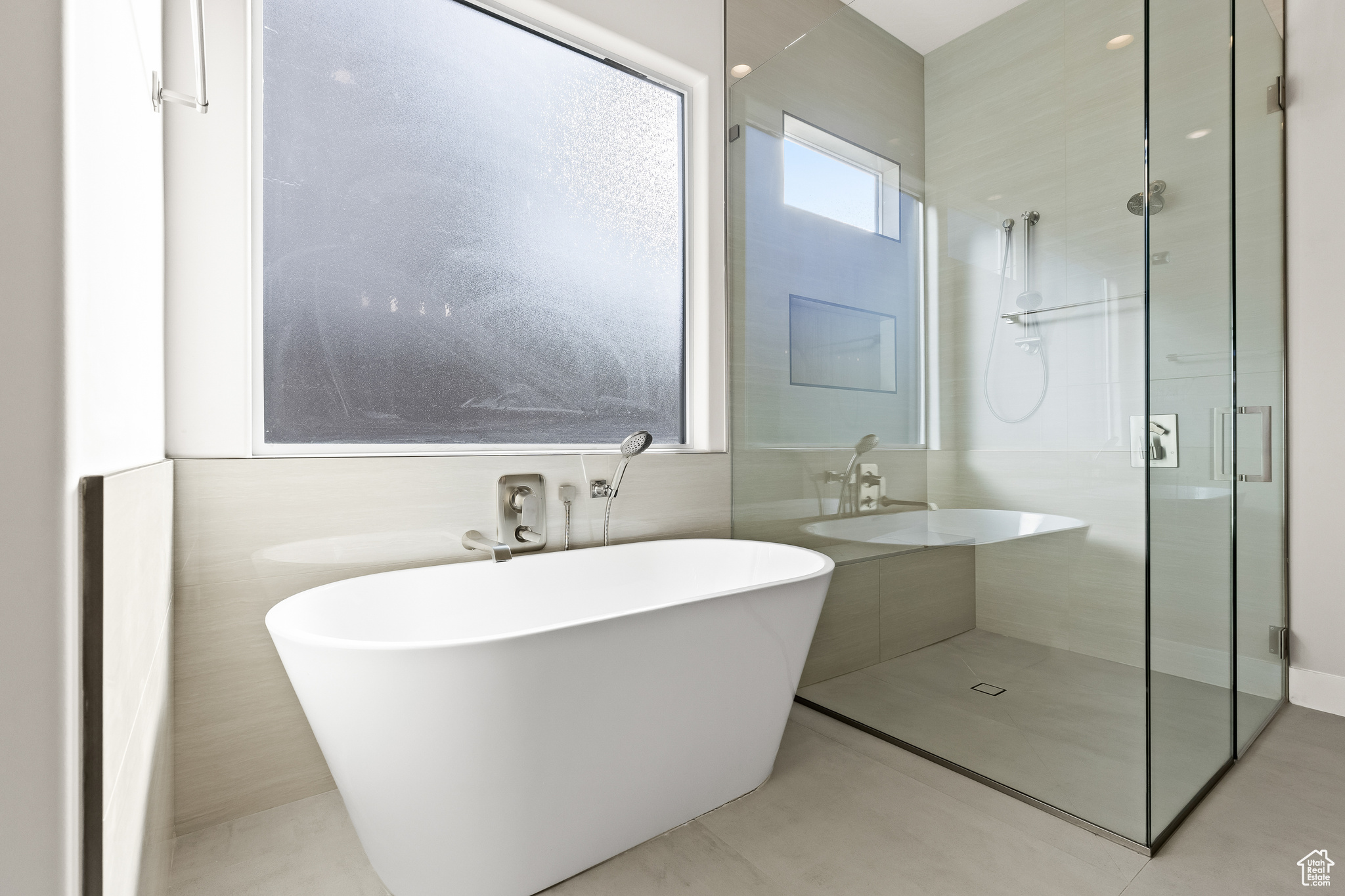 Bathroom featuring a soaking tub and a shower stall