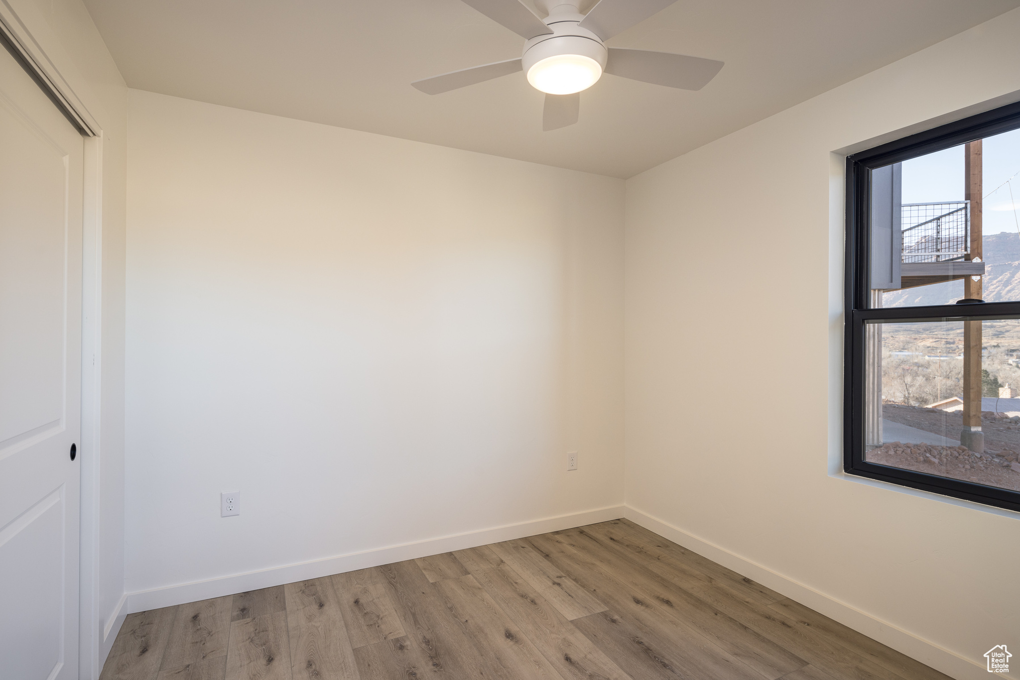 Unfurnished room with ceiling fan and light wood-type flooring
