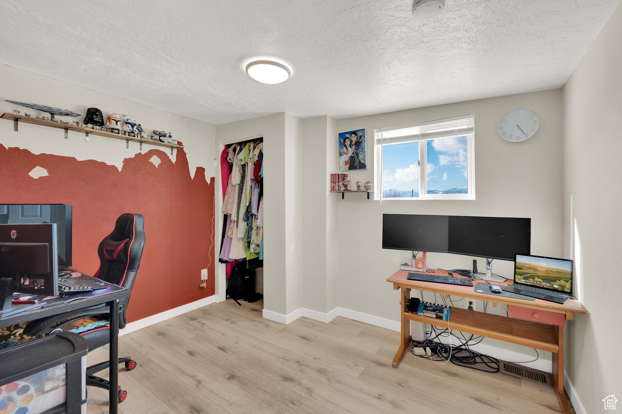 Office space featuring a textured ceiling and light wood-type flooring