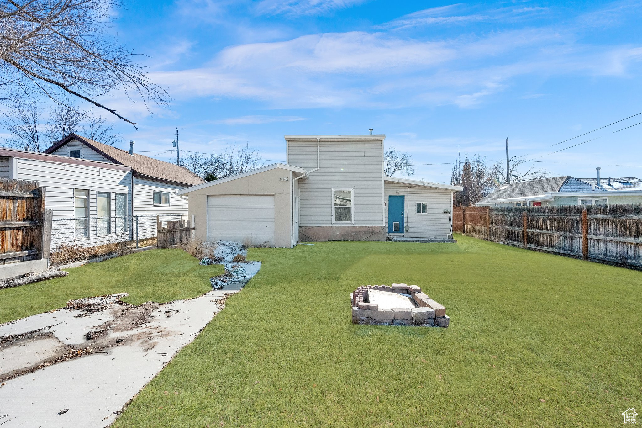 Rear view of property with a fire pit and a lawn