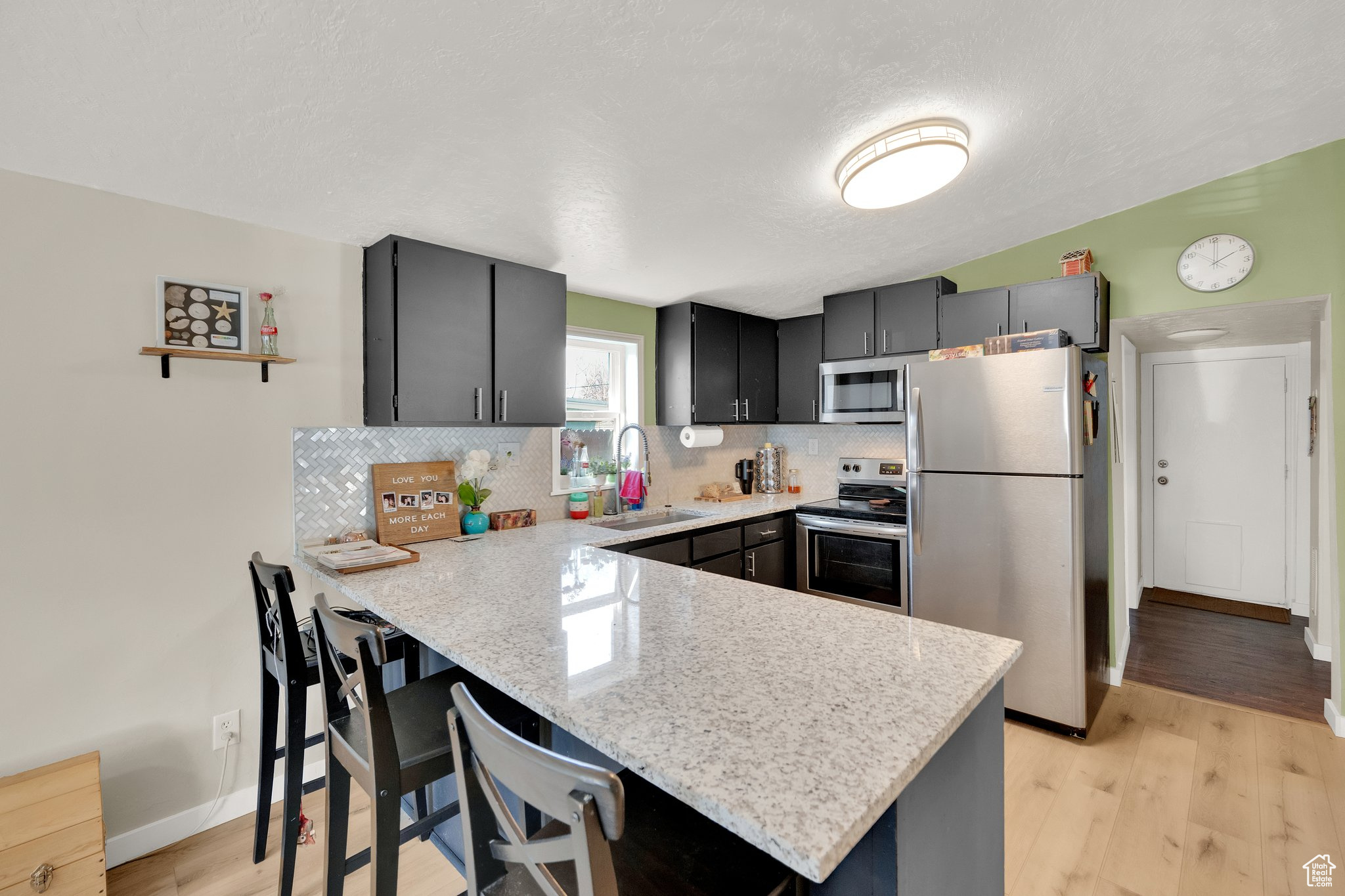 Kitchen featuring sink, a breakfast bar, kitchen peninsula, and appliances with stainless steel finishes