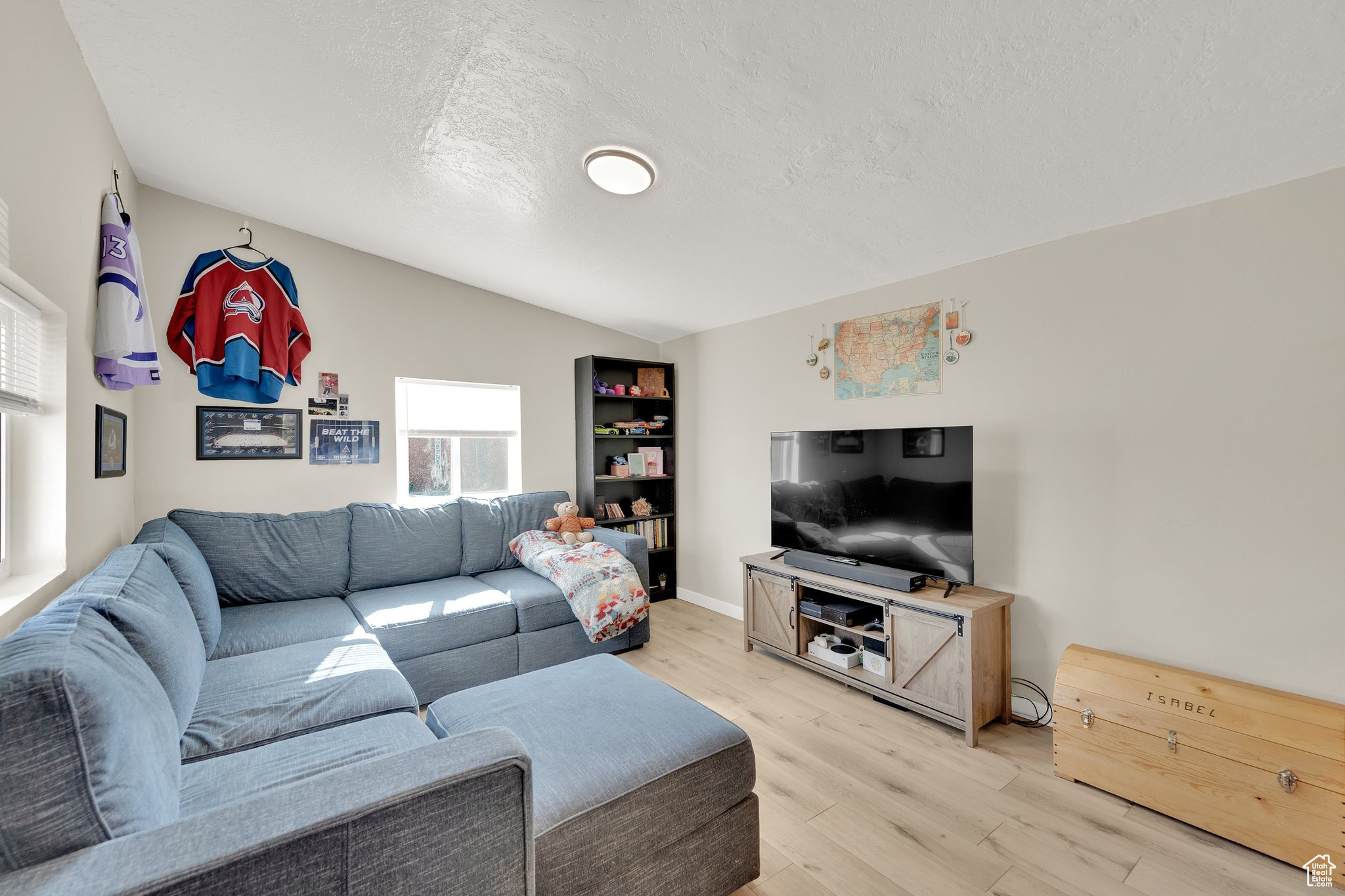 Living room with lofted ceiling, hardwood / wood-style floors, and a textured ceiling