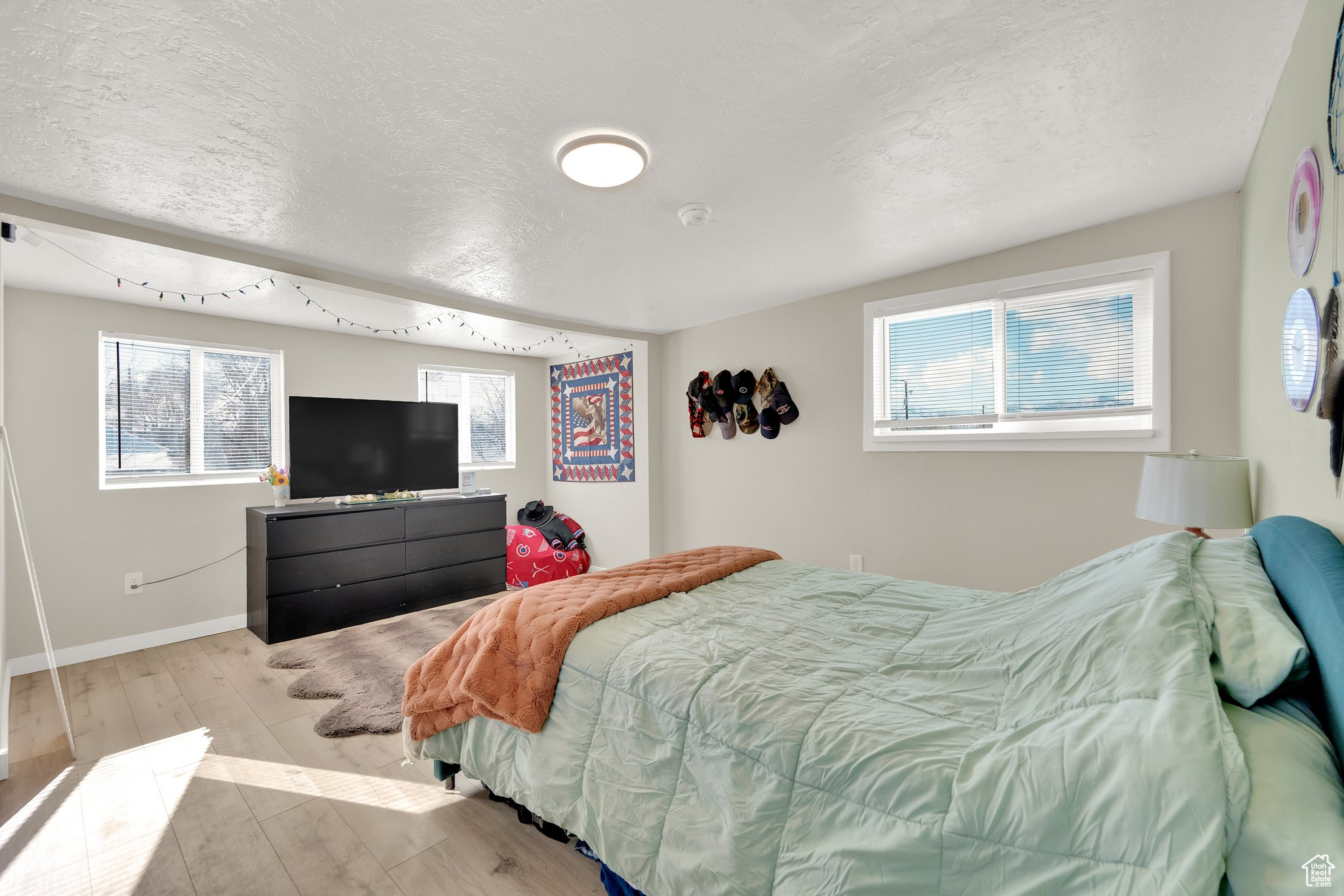 Bedroom with light hardwood / wood-style floors and a textured ceiling