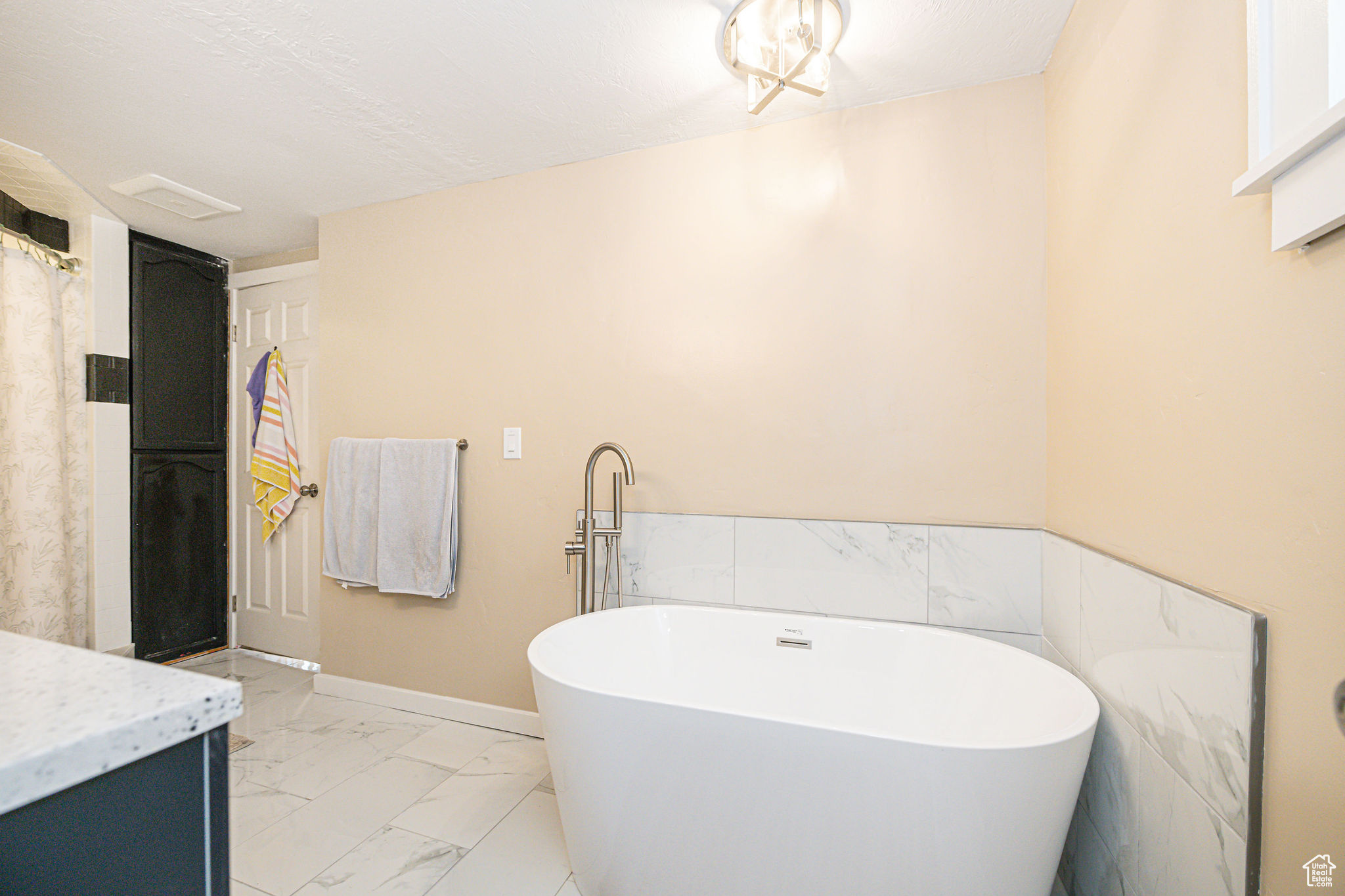 Bathroom featuring vanity, a textured ceiling, and a washtub