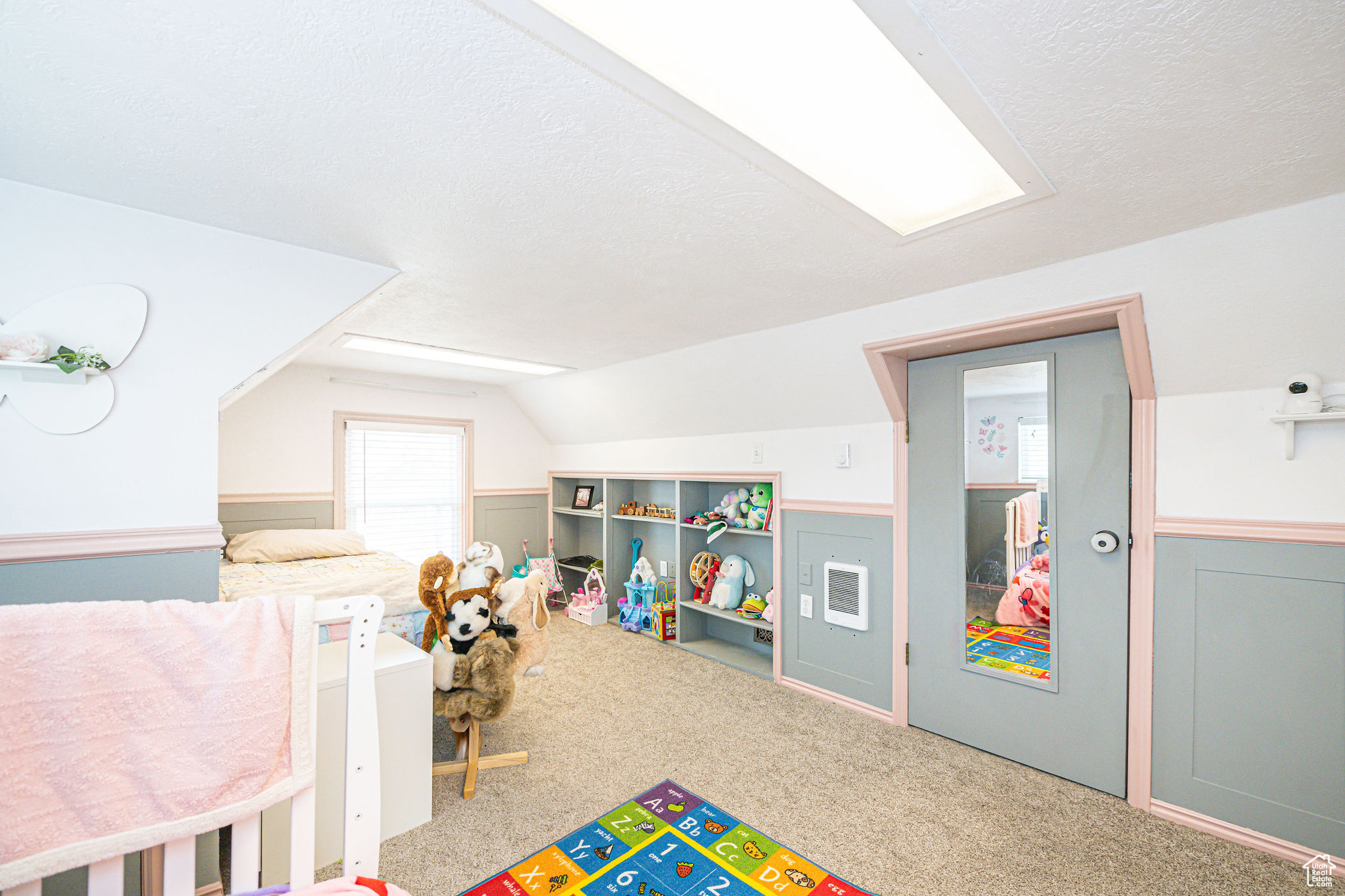 Recreation room featuring lofted ceiling, carpet floors, and a textured ceiling