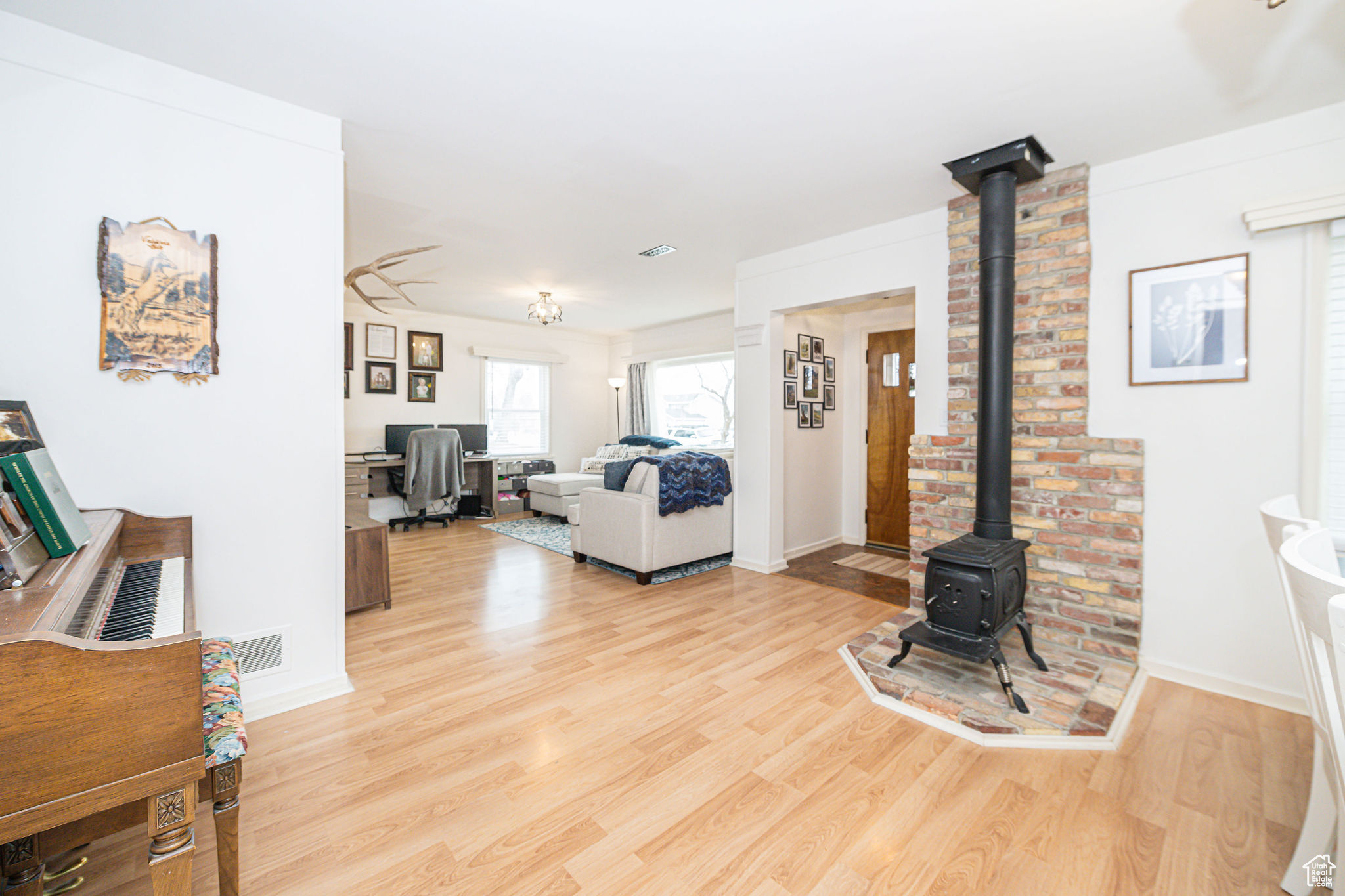 Living room with light hardwood / wood-style floors and a wood stove