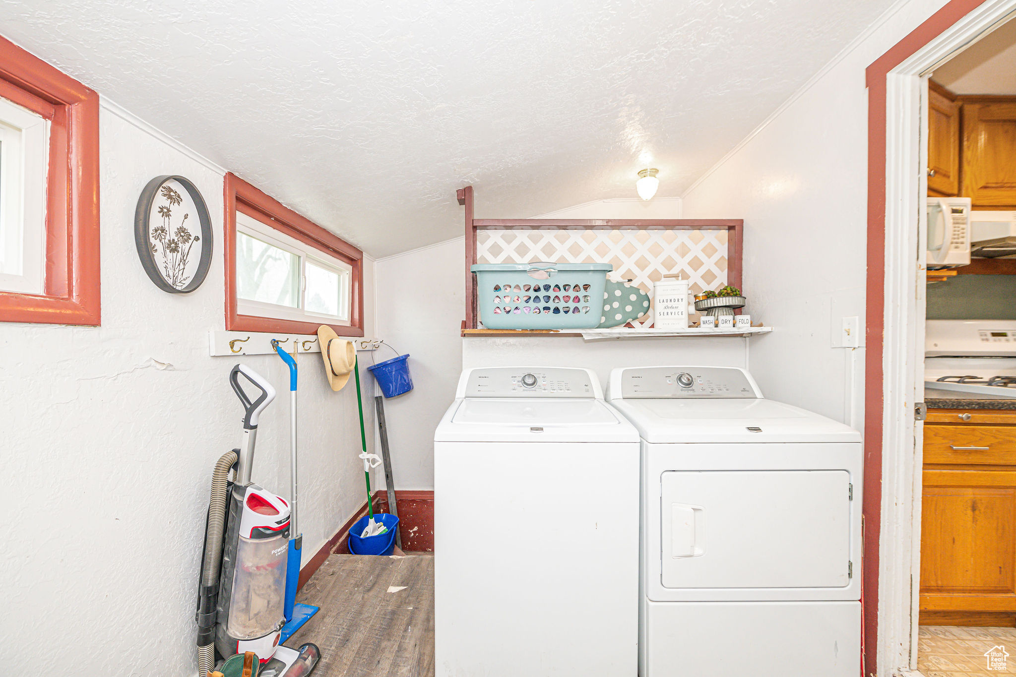 Laundry area featuring wood-type flooring, washing machine and clothes dryer, and a textured ceiling