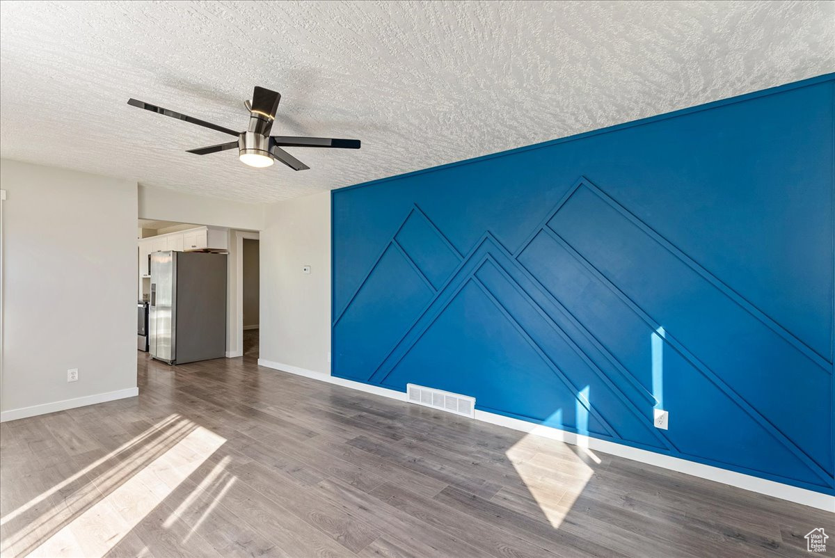 Spare room with hardwood / wood-style floors, a textured ceiling, and ceiling fan