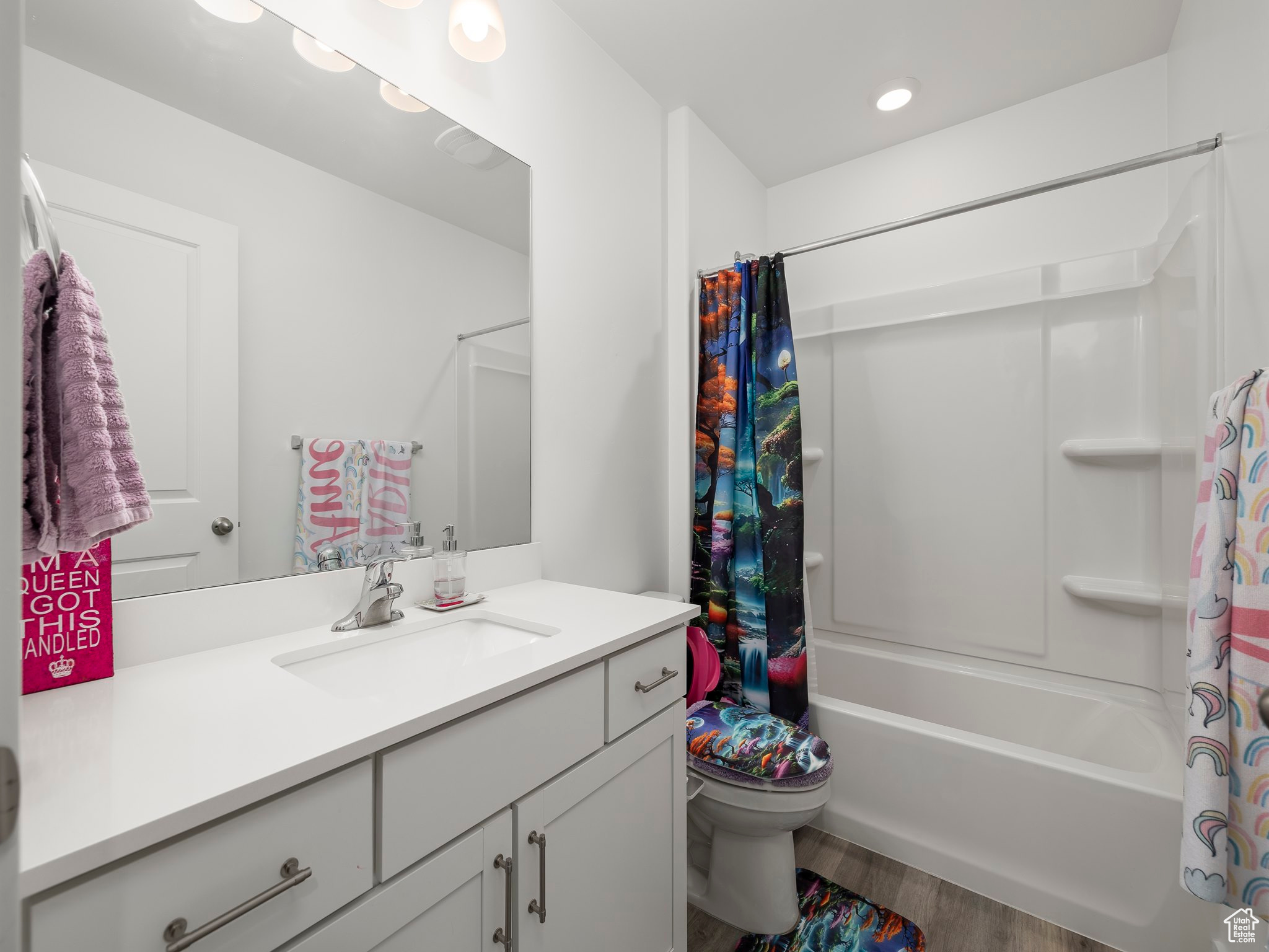 Full bathroom with vanity, hardwood / wood-style floors, toilet, and shower / bathtub combination with curtain