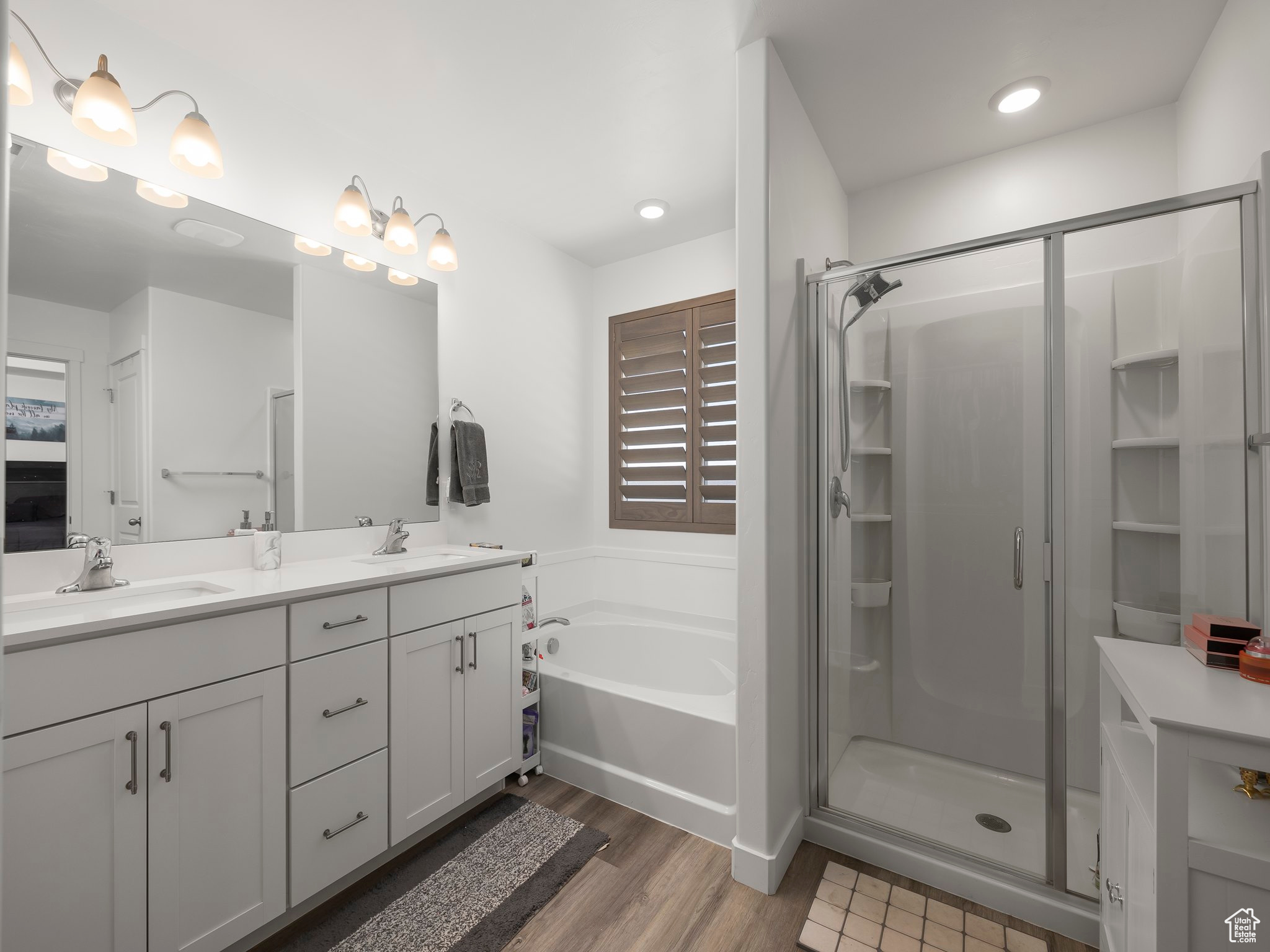 Bathroom with vanity, separate shower and tub, and hardwood / wood-style floors