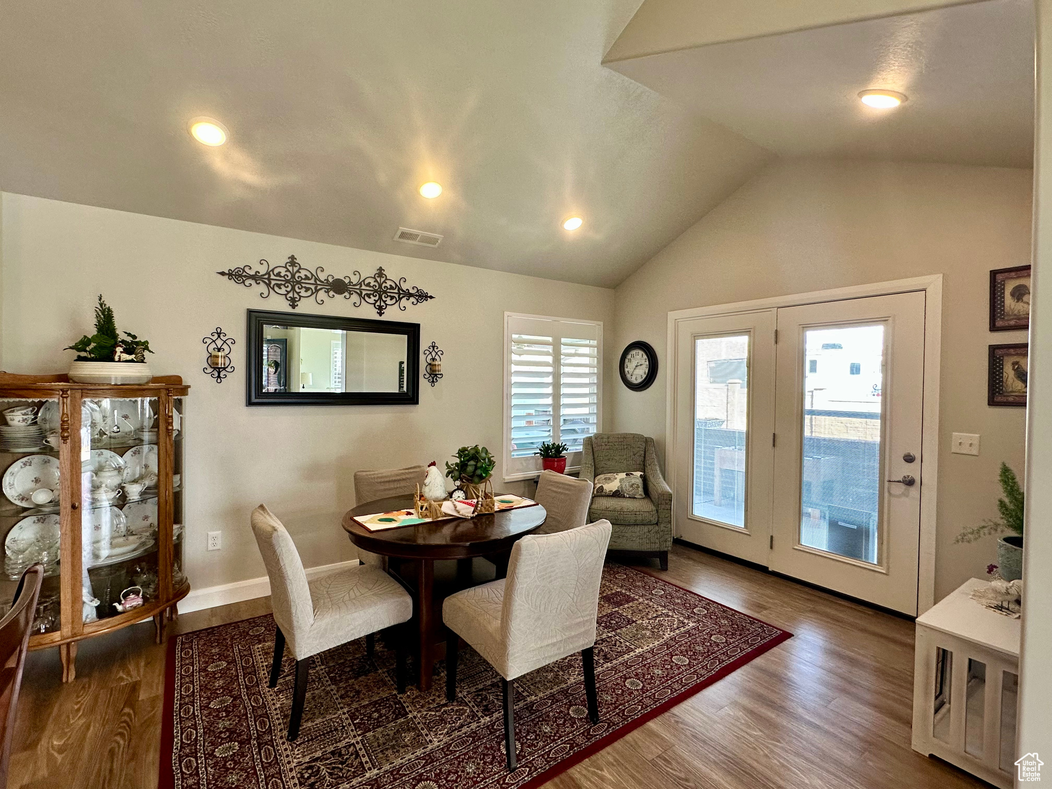 Dining area featuring lofted ceiling, recessed lighting, visible vents, wood finished floors, and baseboards
