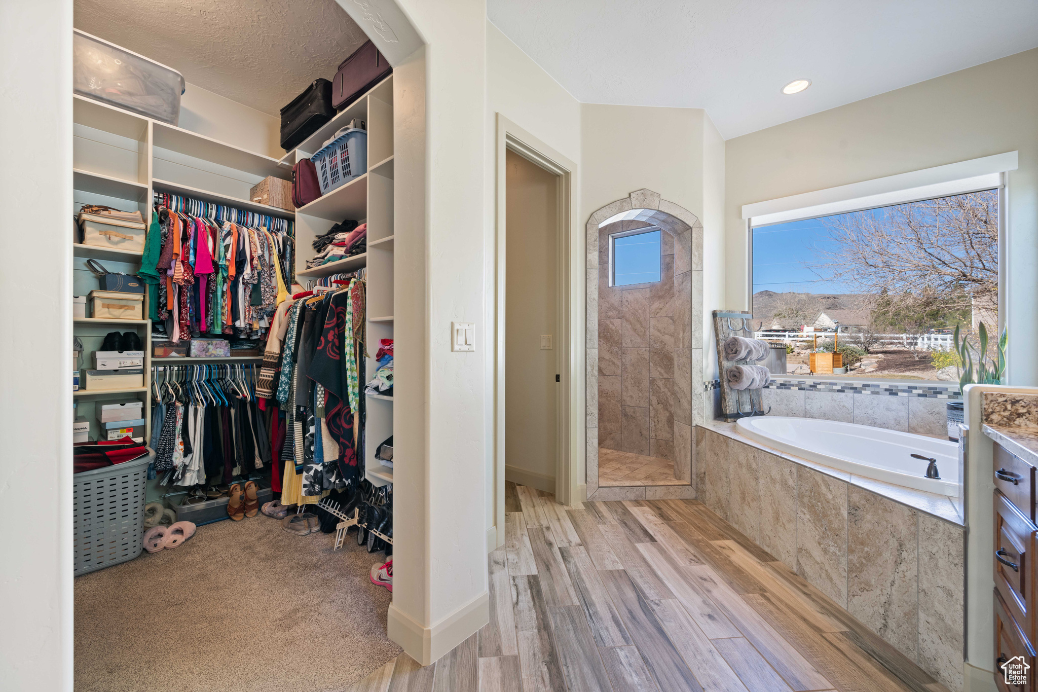 Walk in closet with light hardwood / wood-style flooring