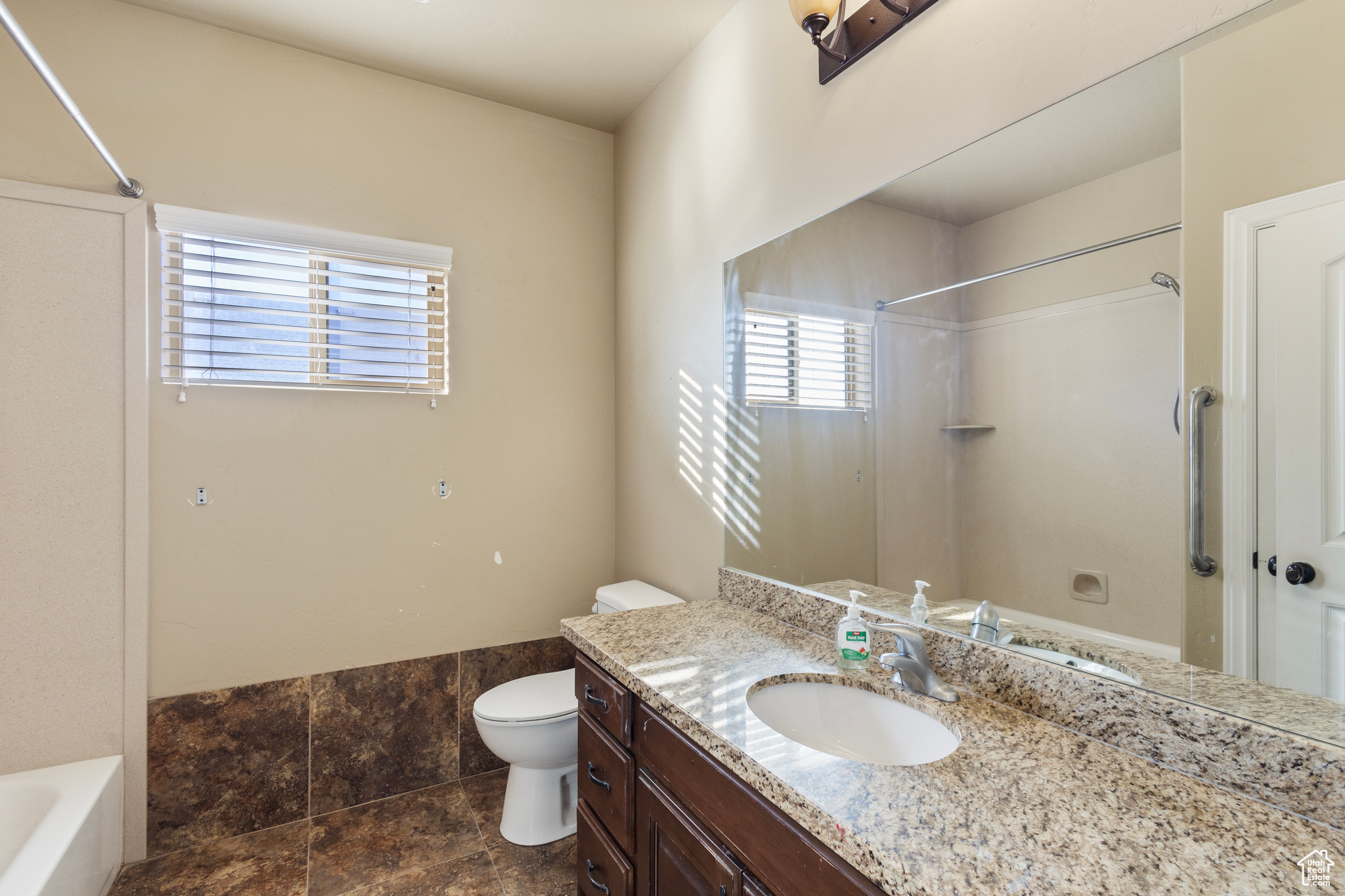 Full bathroom featuring vanity, shower / washtub combination, and toilet