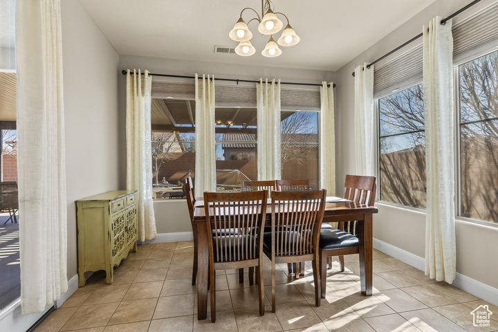 Tiled dining area with plenty of natural light and a notable chandelier