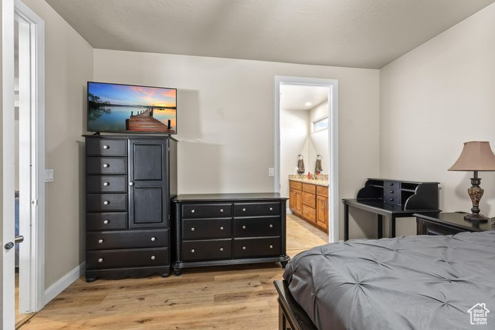 Bedroom with ensuite bath and light hardwood / wood-style flooring
