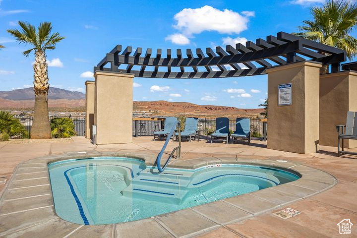 View of pool with a community hot tub, a pergola, a mountain view, and a patio